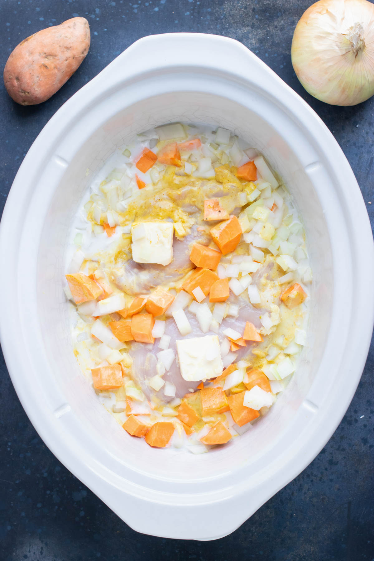 Sweet potatoes and seasoning are added to the slow cooker.
