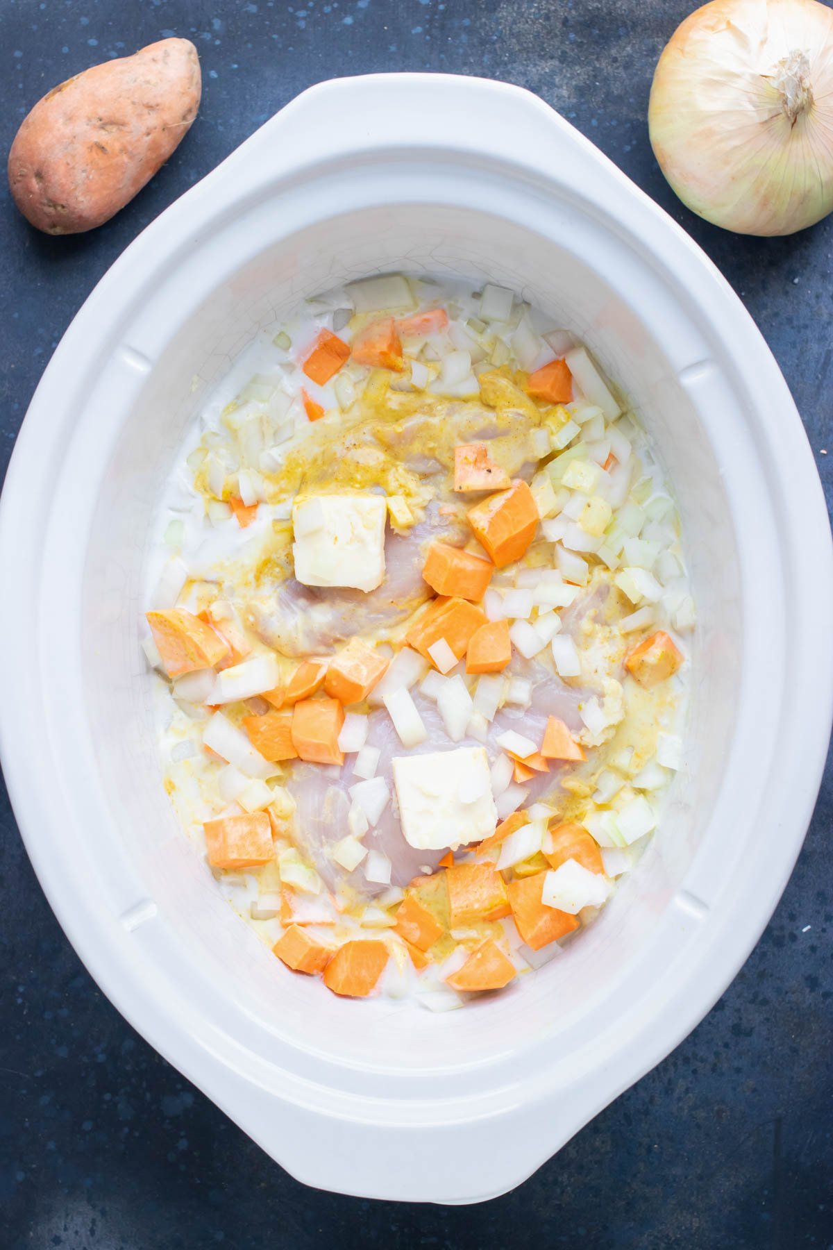 Sweet potatoes and seasoning are added to the slow cooker.