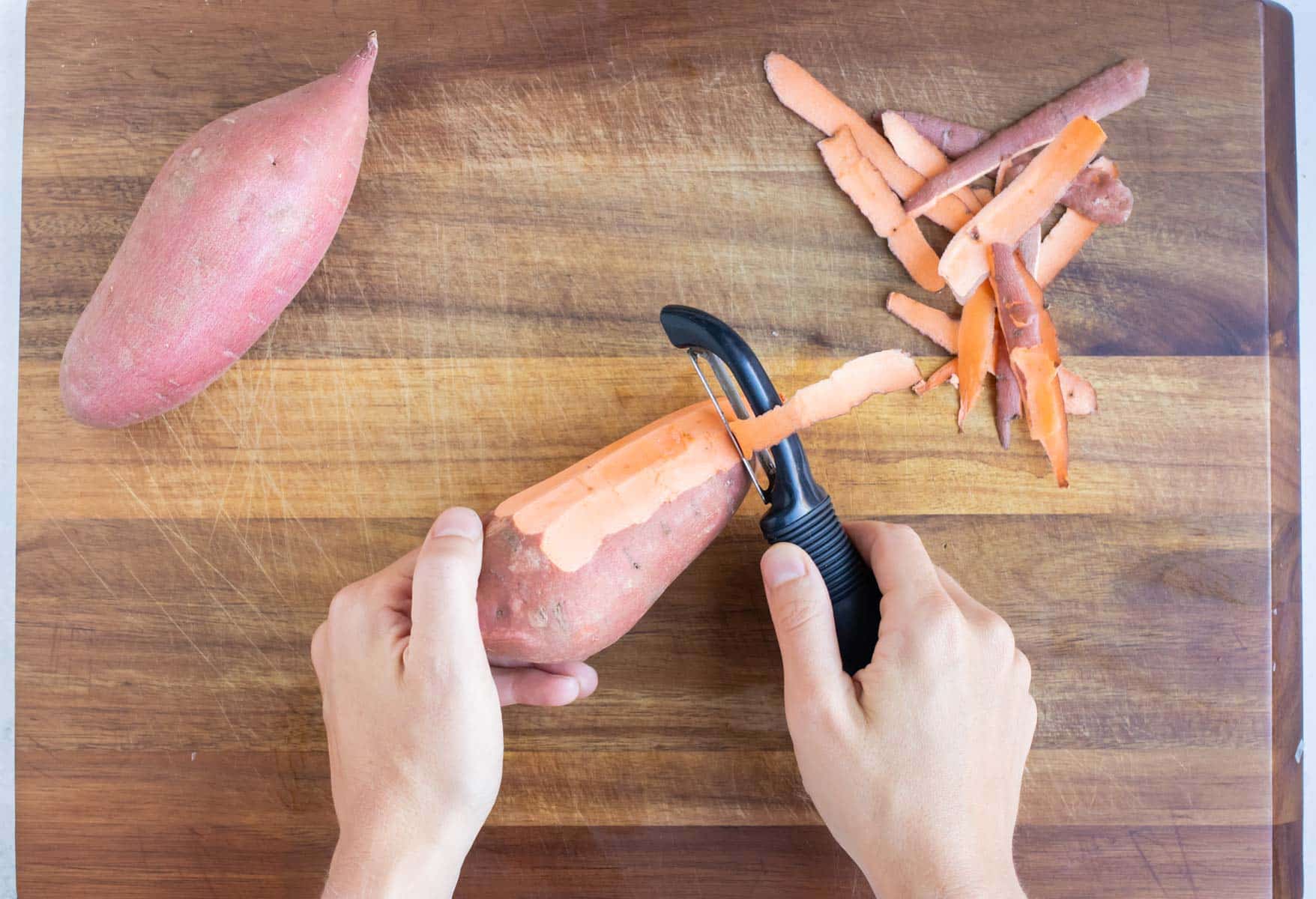Sweet potatoes are peeled before chopping for the vegetarian enchilada filling.