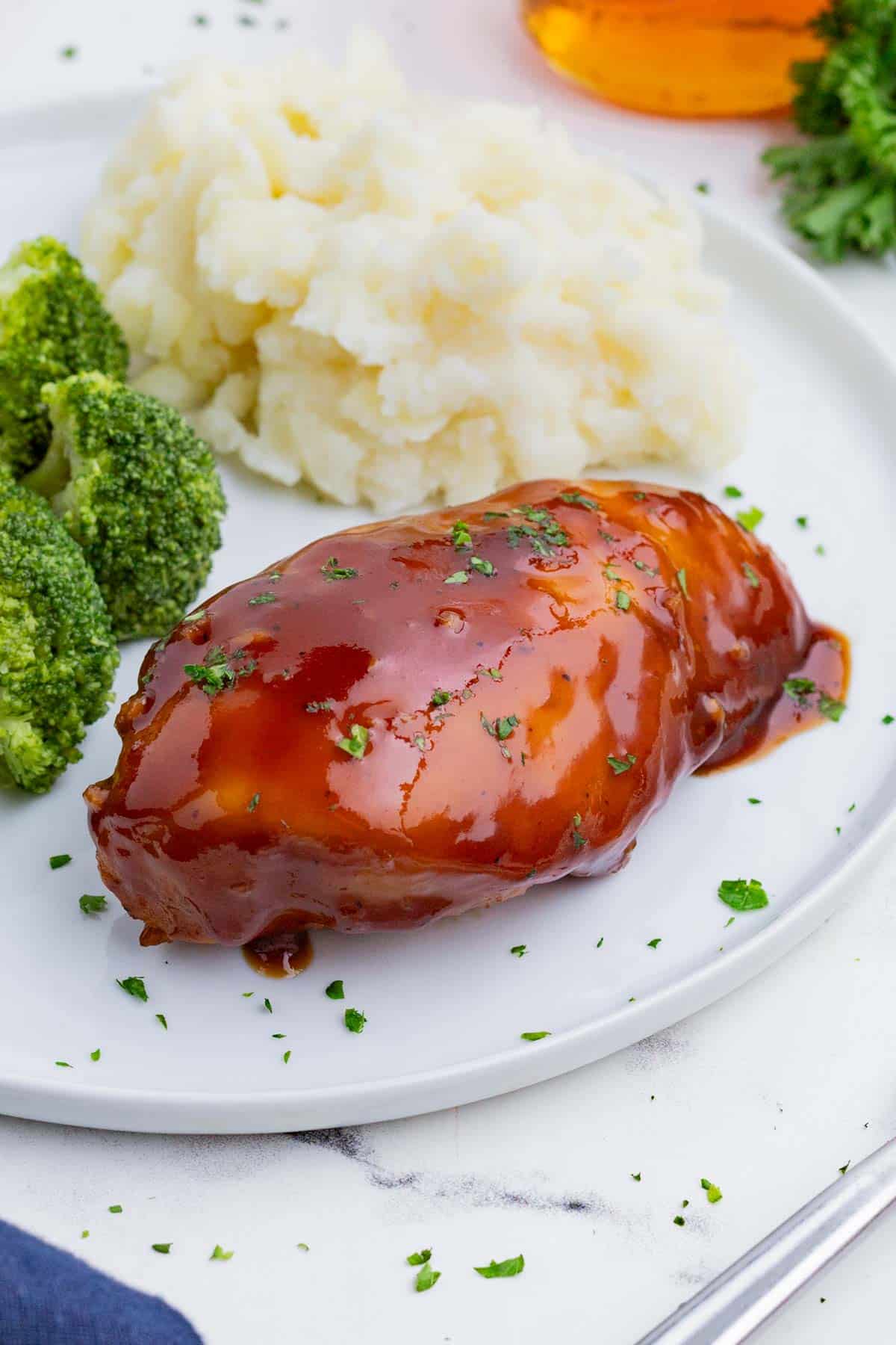 Chicken breasts are marinated in a BBQ sauce and baked in the oven.