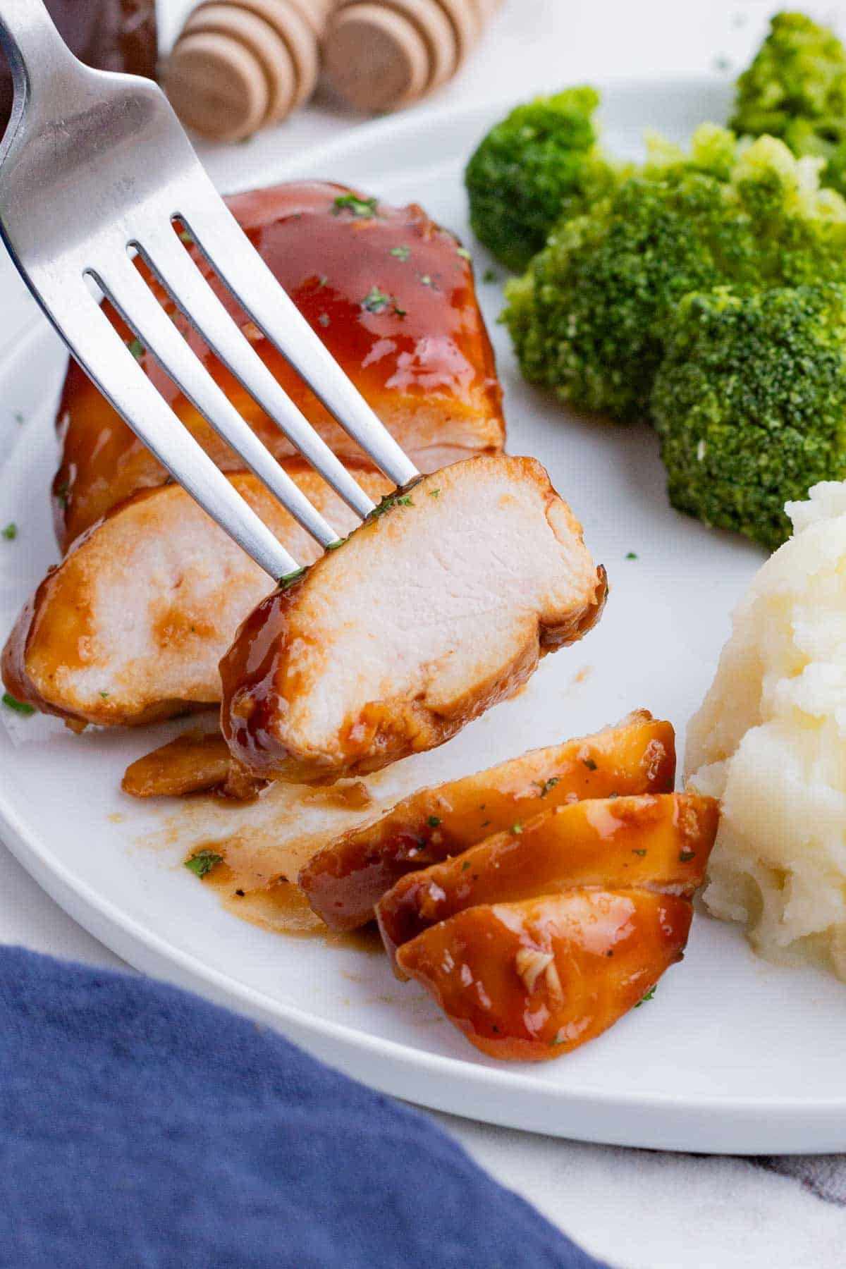 Oven baked bbq chicken is served alongside potatoes and broccoli.