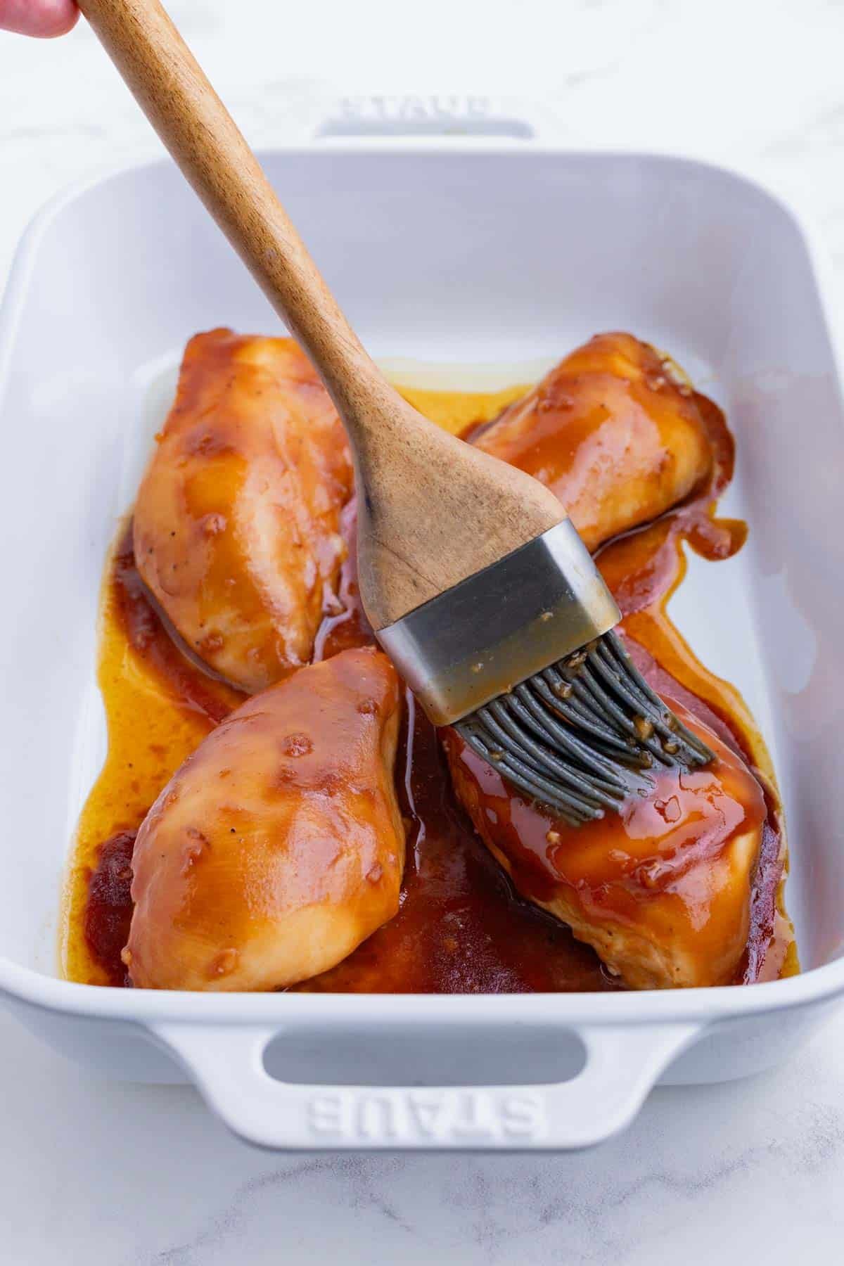 Marinade is brushed on the chicken breasts in the oven.