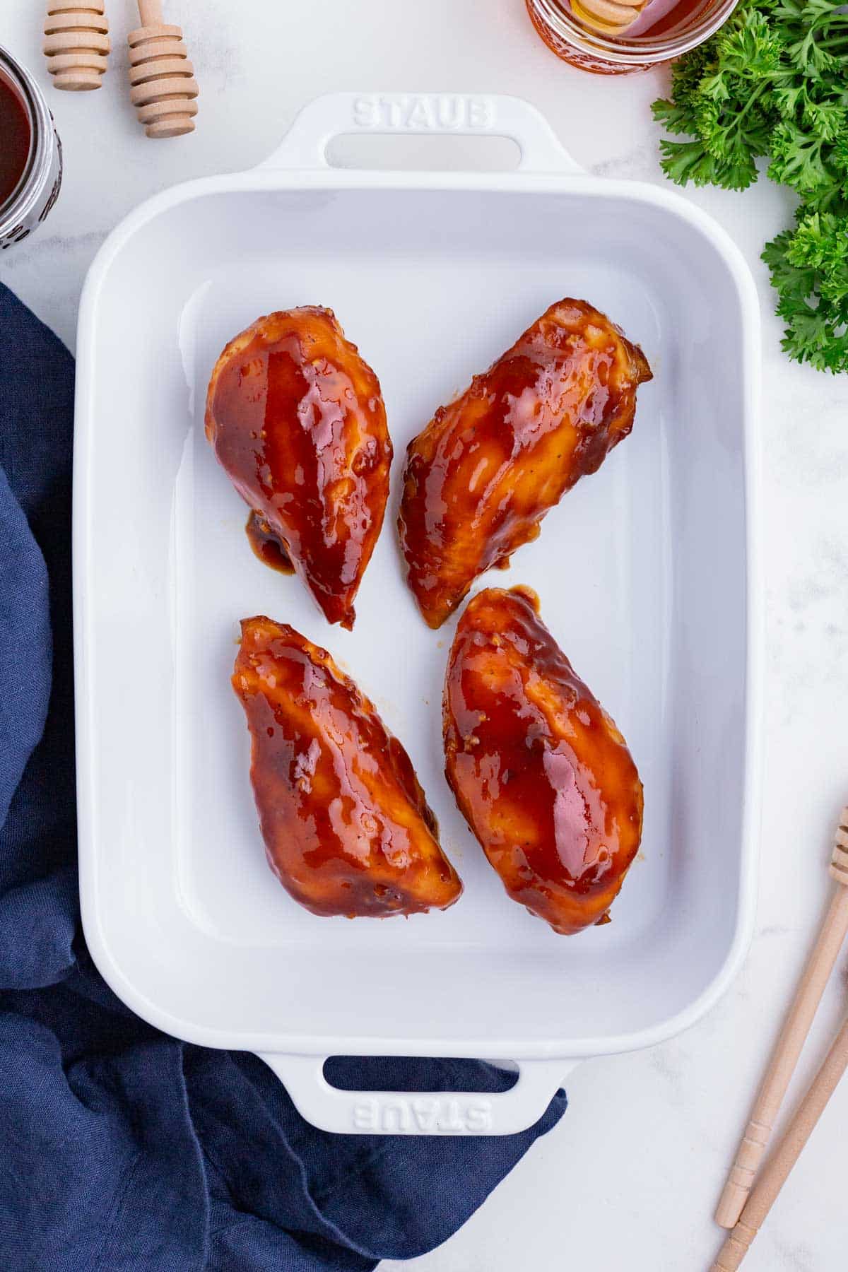 BBQ chicken is baked in the oven in a casserole dish.