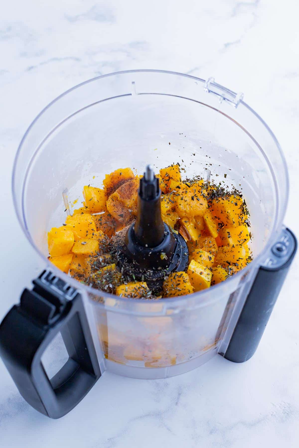 Butternut squash and seasonings are blended in a food processor.