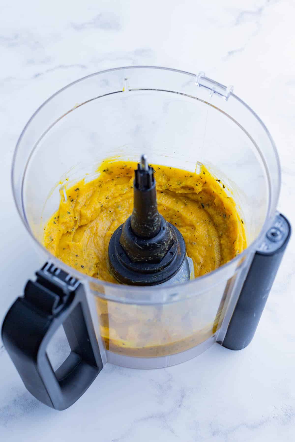 Butternut squash and seasonings are blended in a food processor.