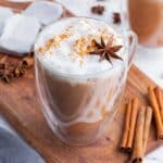 A chai latte topped with warming spices like cinnamon and star anise.