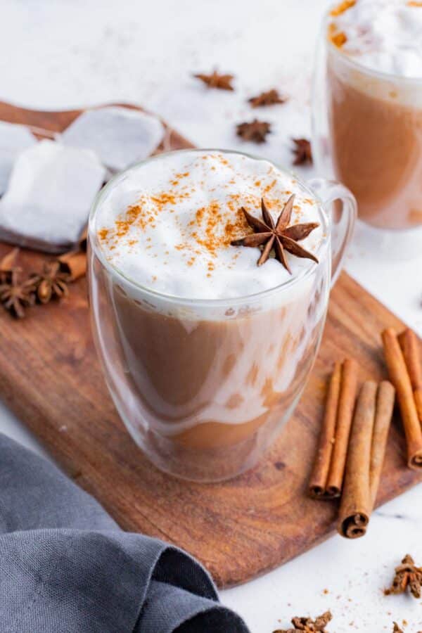 A chai latte topped with warming spices like cinnamon and star anise.