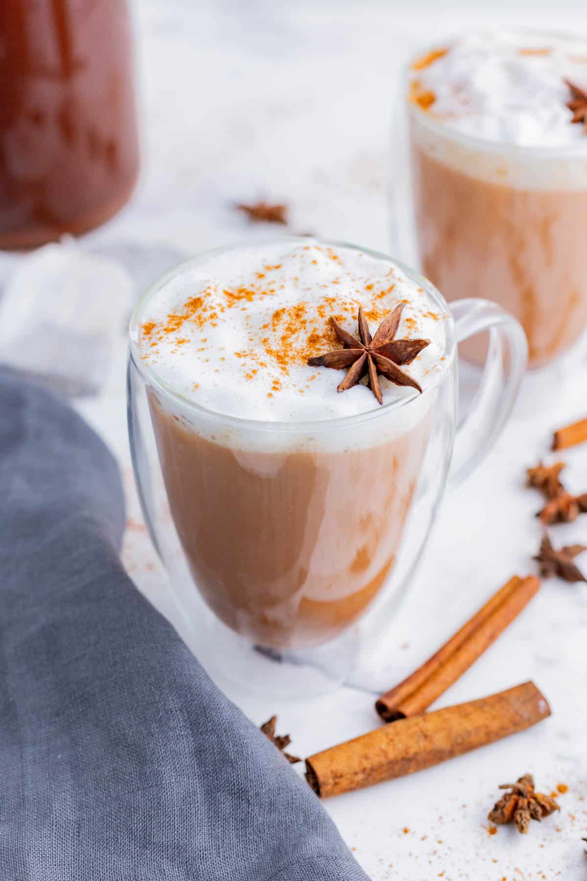 Warm spices, like cinnamon and star anise, top glasses of hot Chai tea.