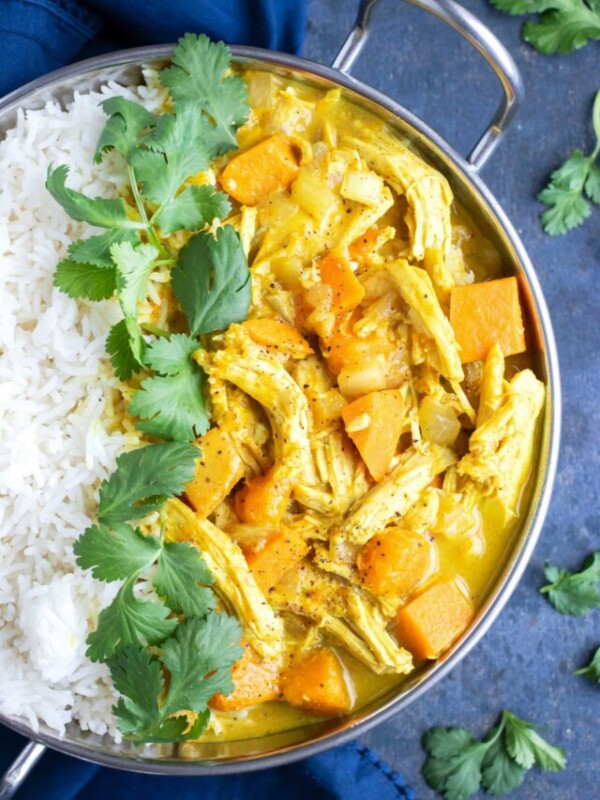 A serving platter full of a yellow chicken curry recipe with coconut milk that was made in a slow cooker.