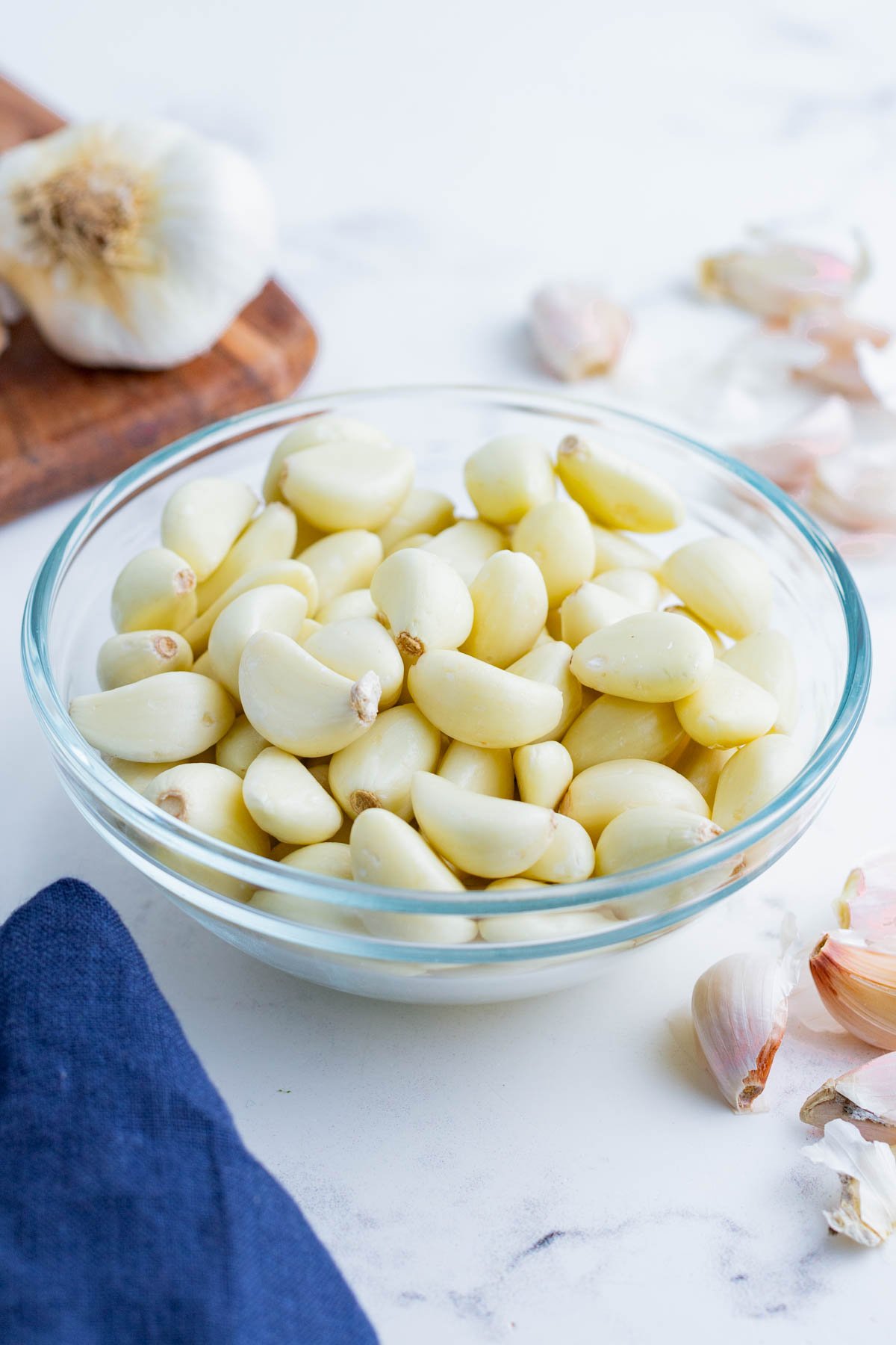 Peeled garlic cloves in a glass bowl.