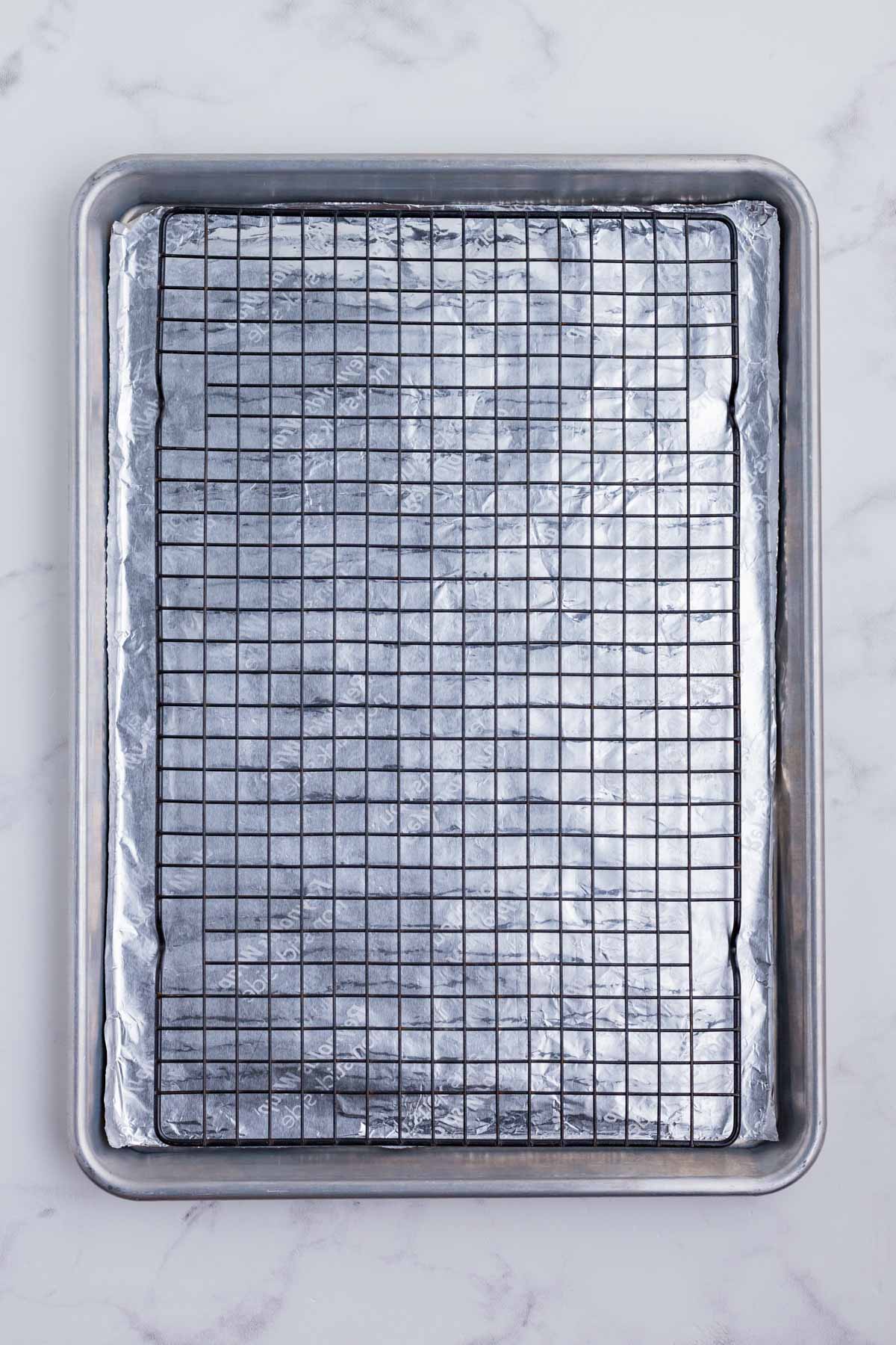 A wire rack is placed over the baking sheet lined with foil.