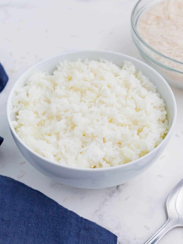 Cooked rice is served in a white bowl as an easy side dish.