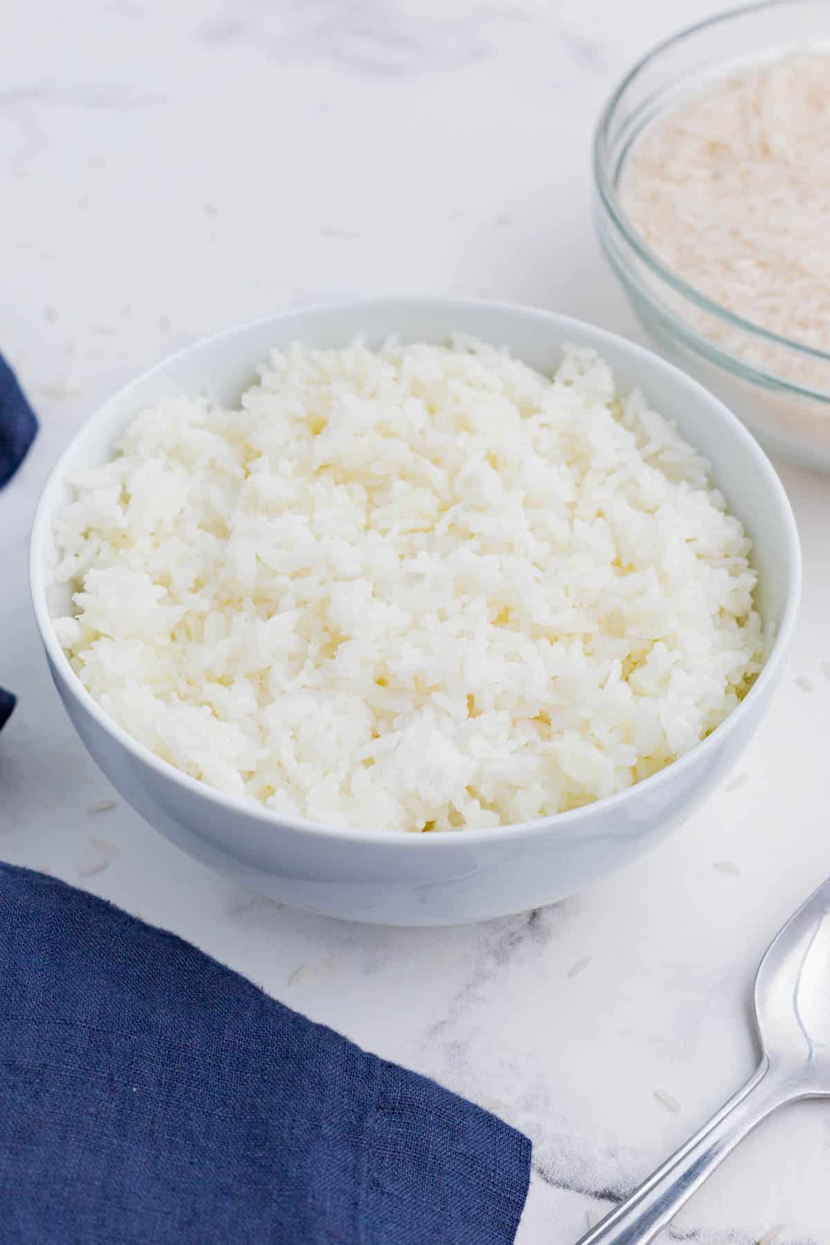 Cooked rice is served in a white bowl as an easy side dish.