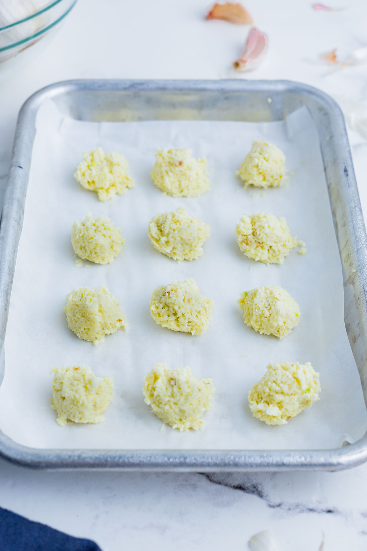 Garlic paste balls on parchment paper on a cookie sheet.