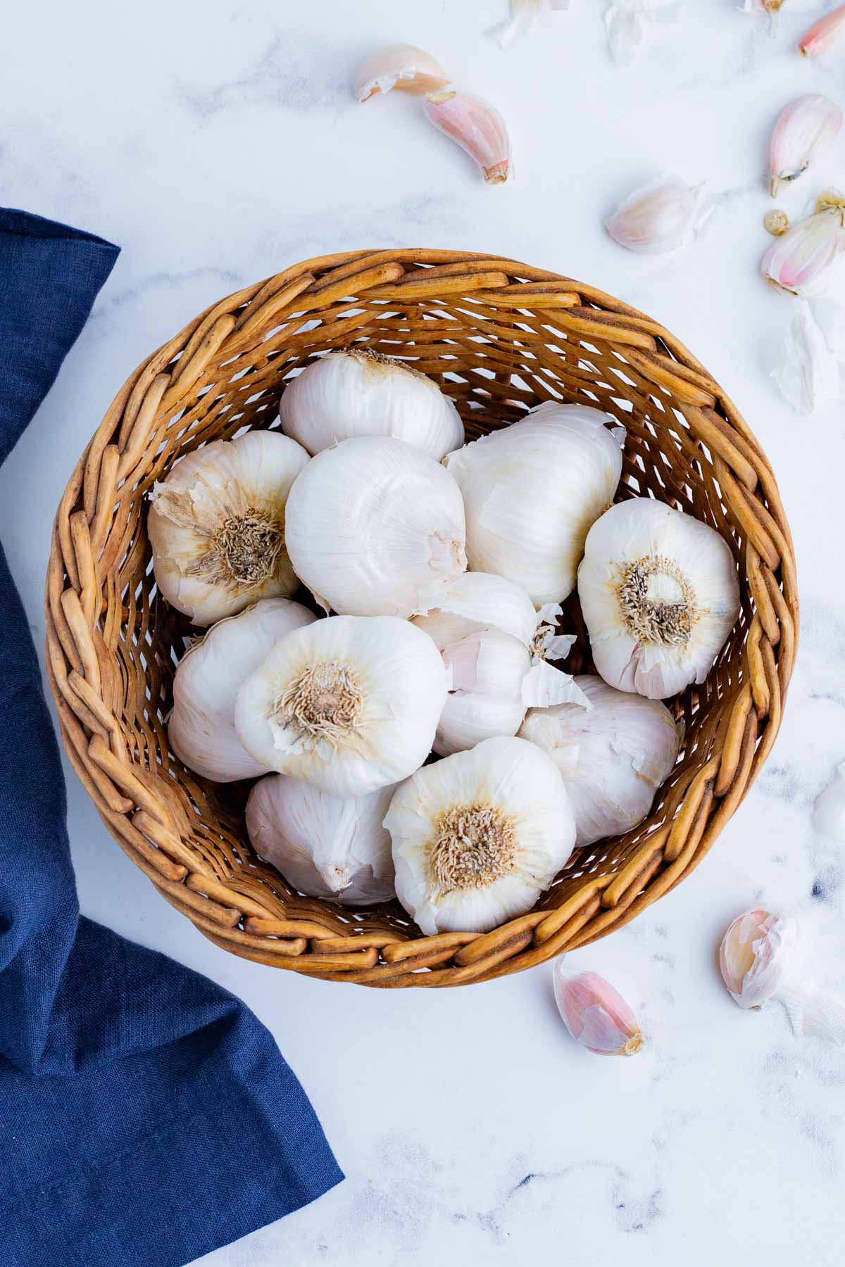 Multiple heads of garlic in a basket.