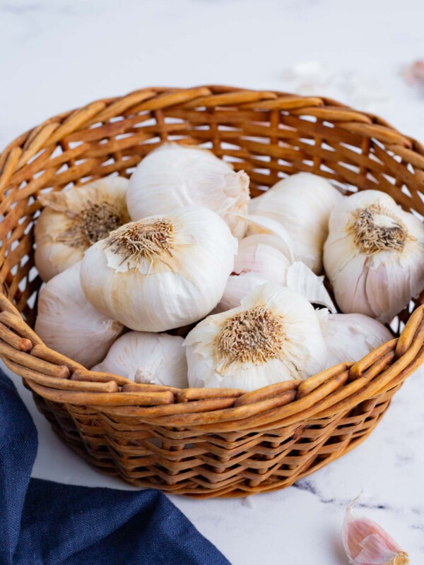 Multiple heads of garlic in a basket.