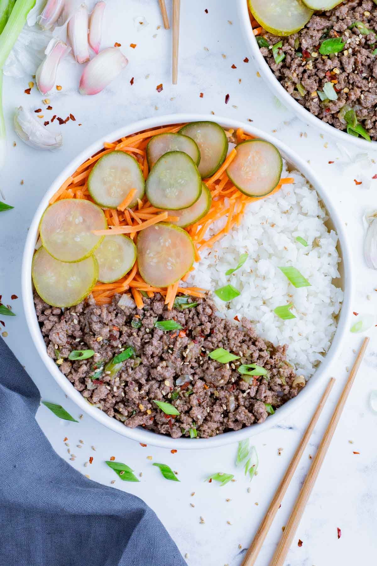 An overhead shot of Korean beef in a bowl with rice and pickled veggies.