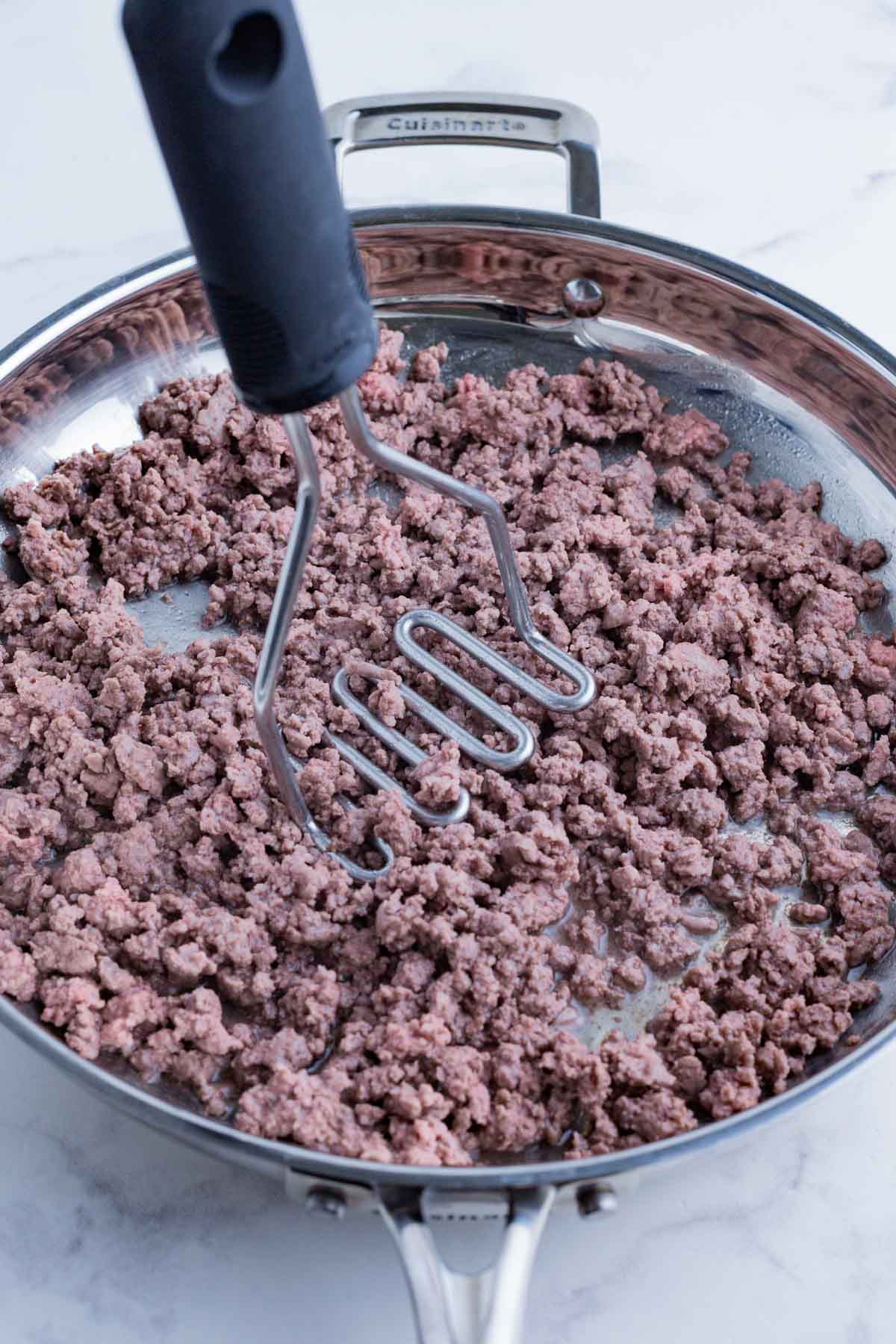 Ground beef is cooked in a skillet.