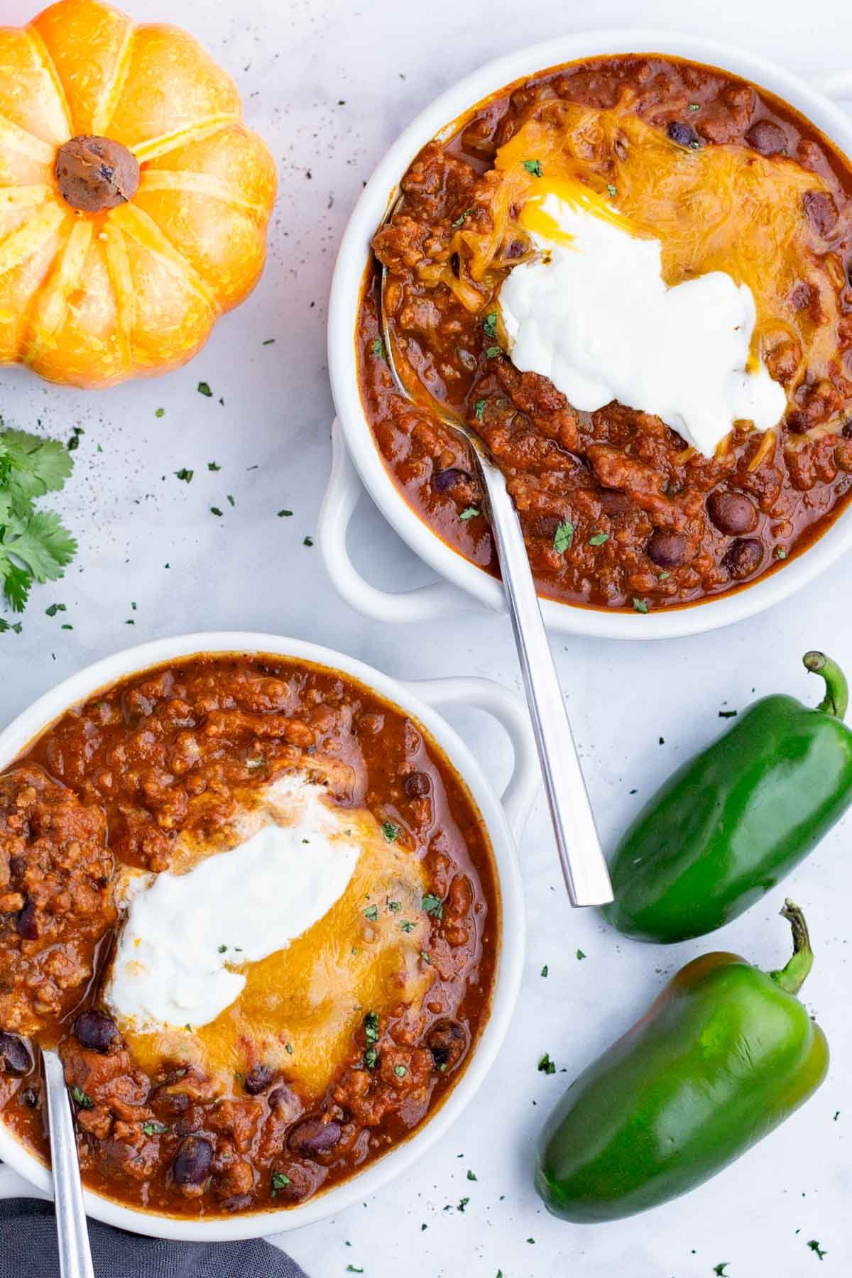 An overhead shot of pumpkin chili in two white bowls.