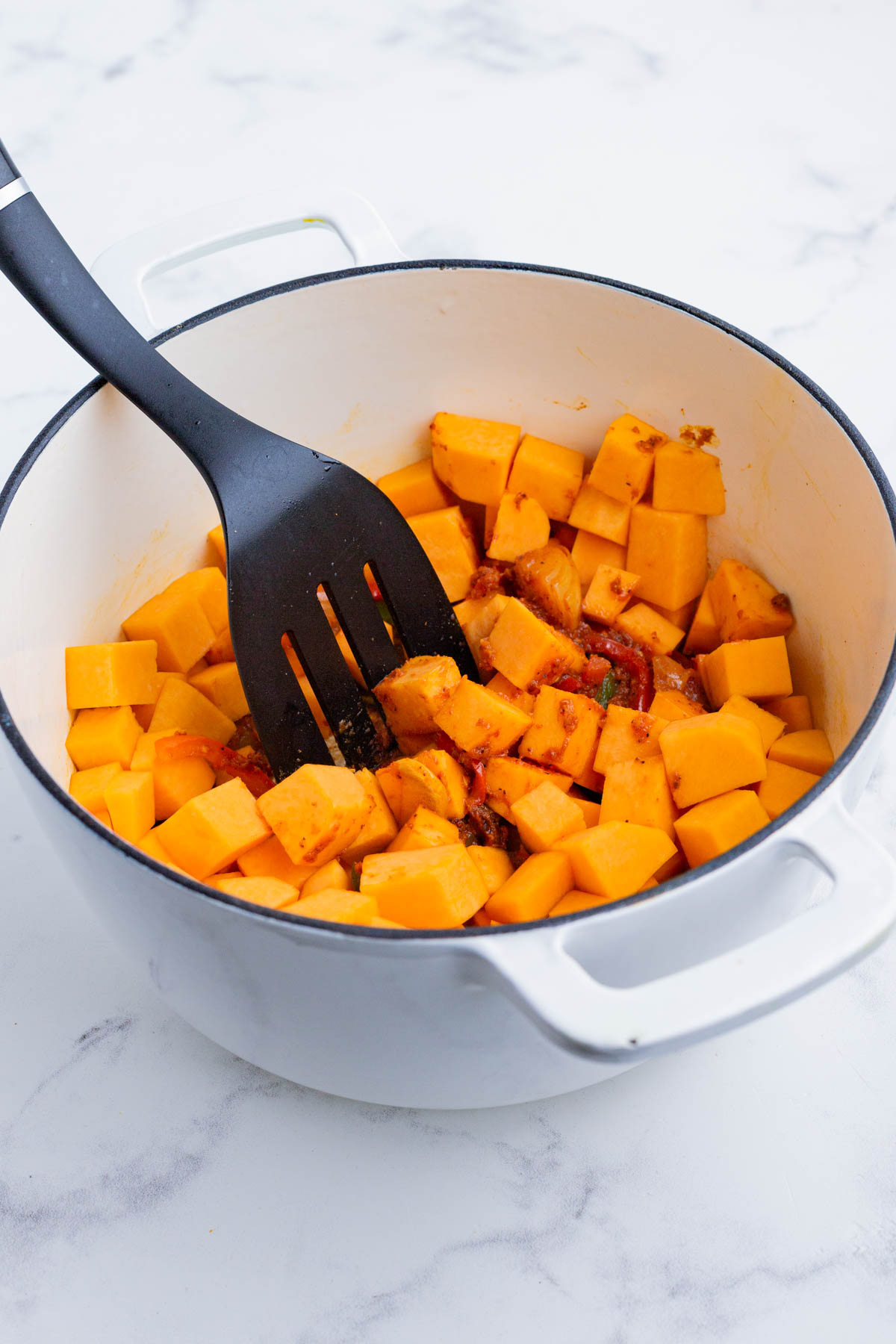 The chopped pumpkin is added to the pot.
