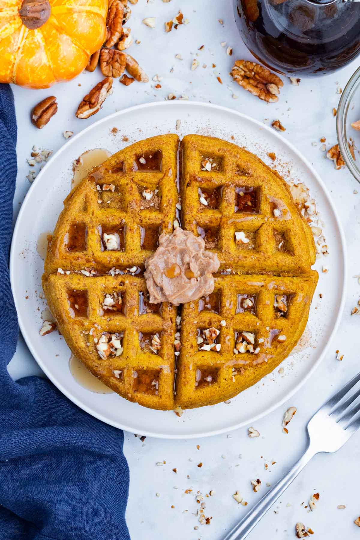 An overhead view of pumpkin waffles served on a white plate.