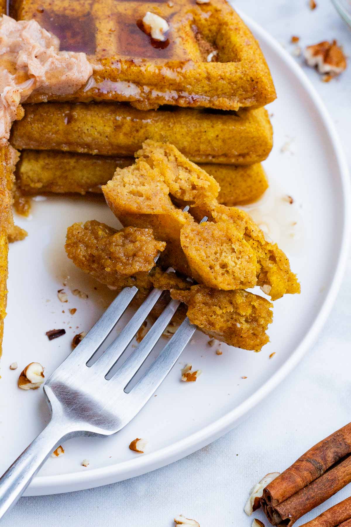Pumpkin waffles are sliced into bite-sized pieces before enjoying.