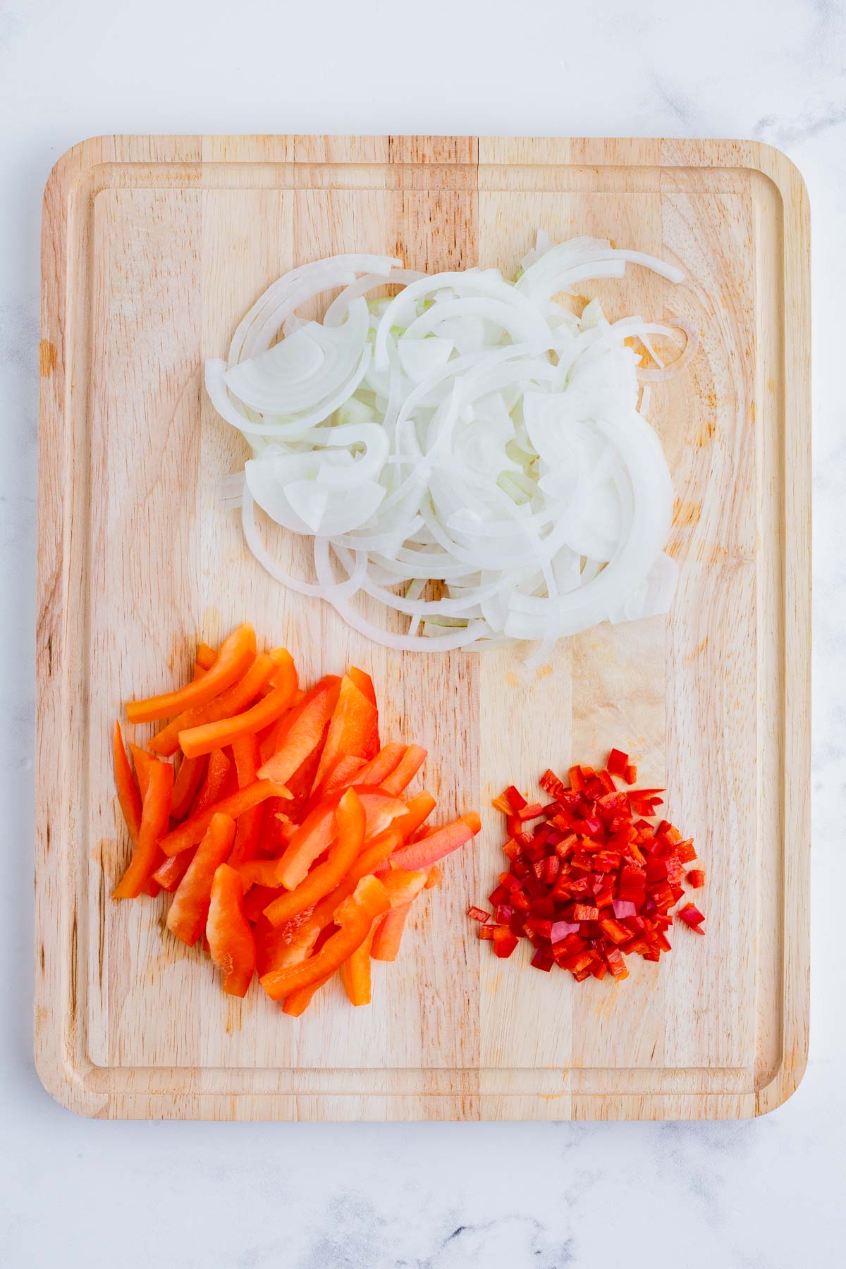 Onions, bell pepper, and Thai chilies are sliced and diced.