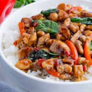 A white bowl is full of Jasmine rice and savory Thai basil chicken.