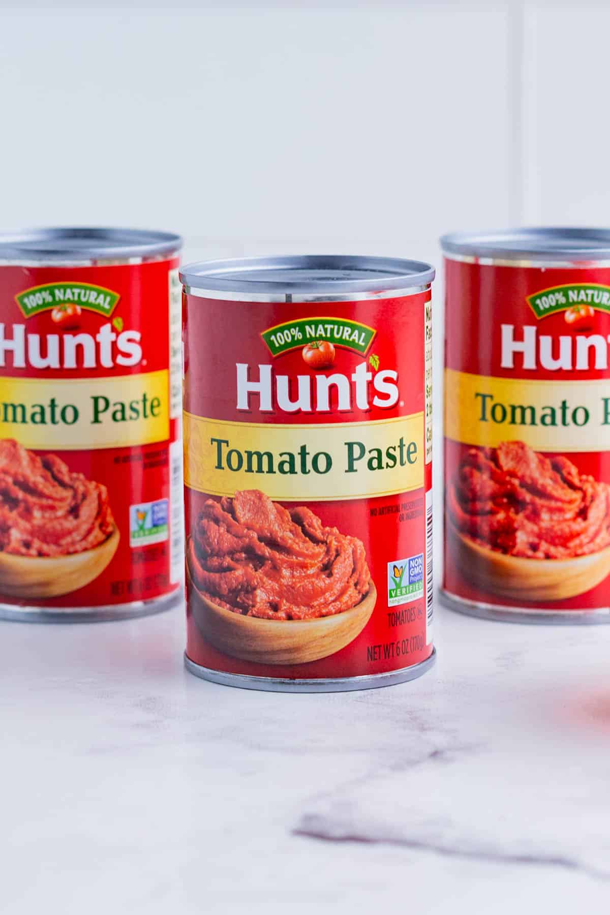 Three cans of 6oz tomato pastes on the counter.