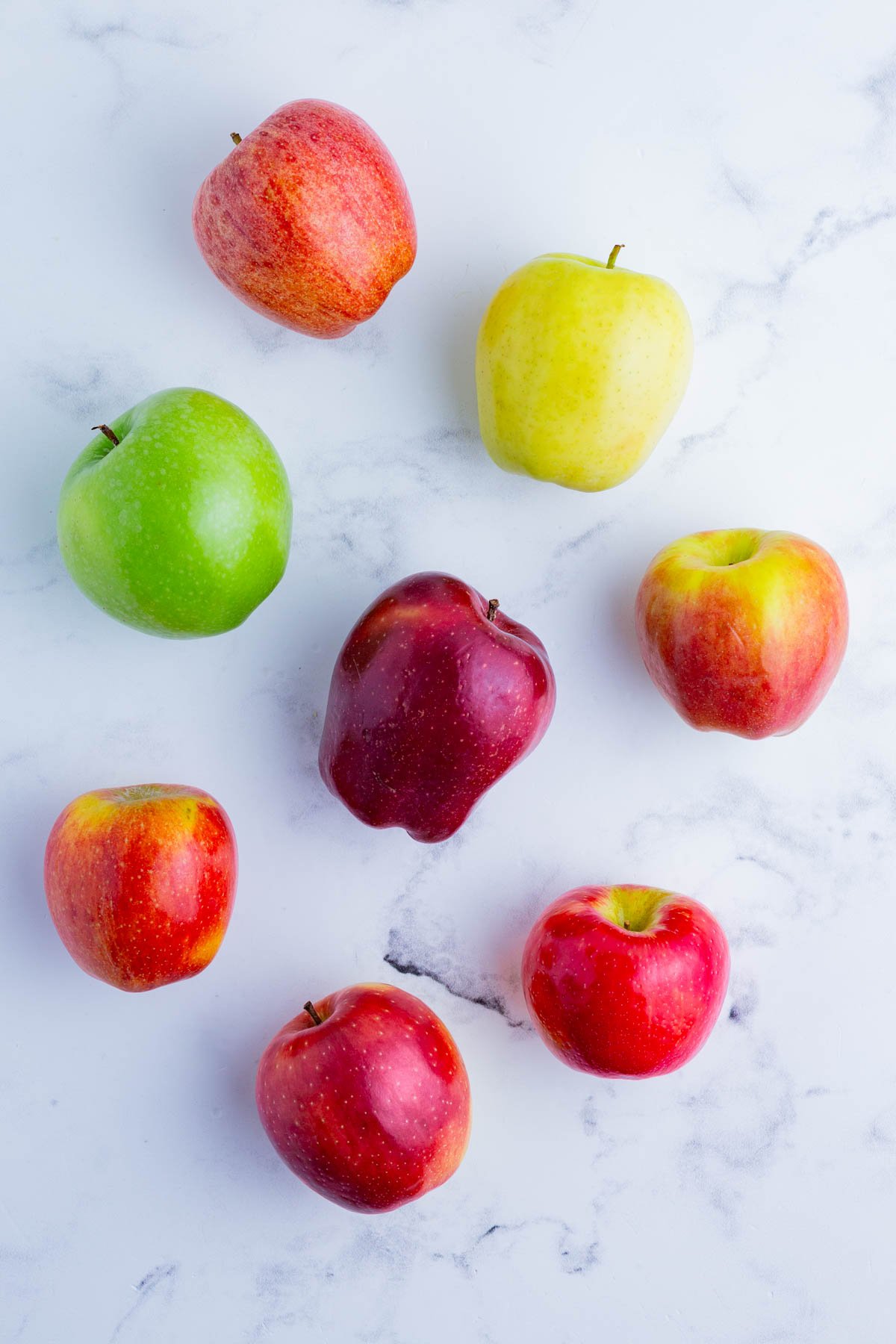 Different types of apples on the countertop -- birds eye view.
