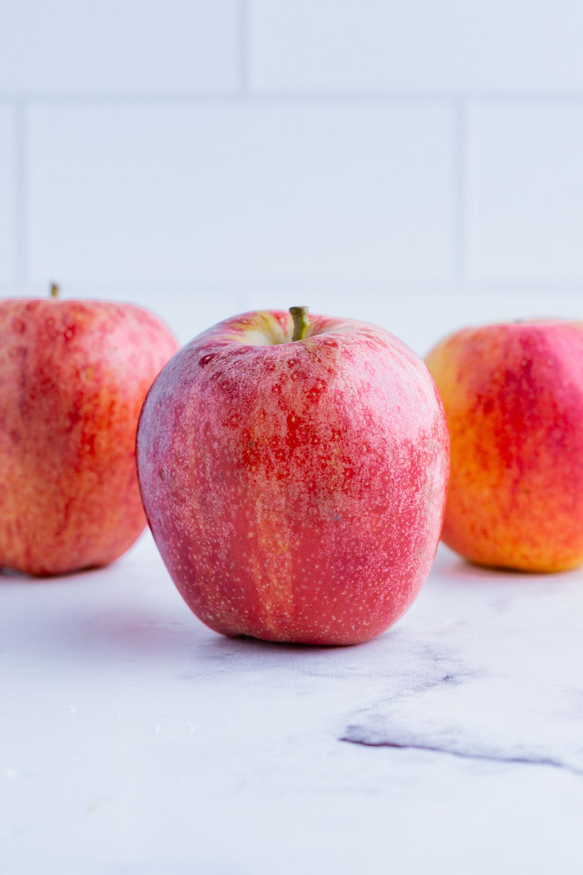 3 Honey Crisp apples on the counter top.