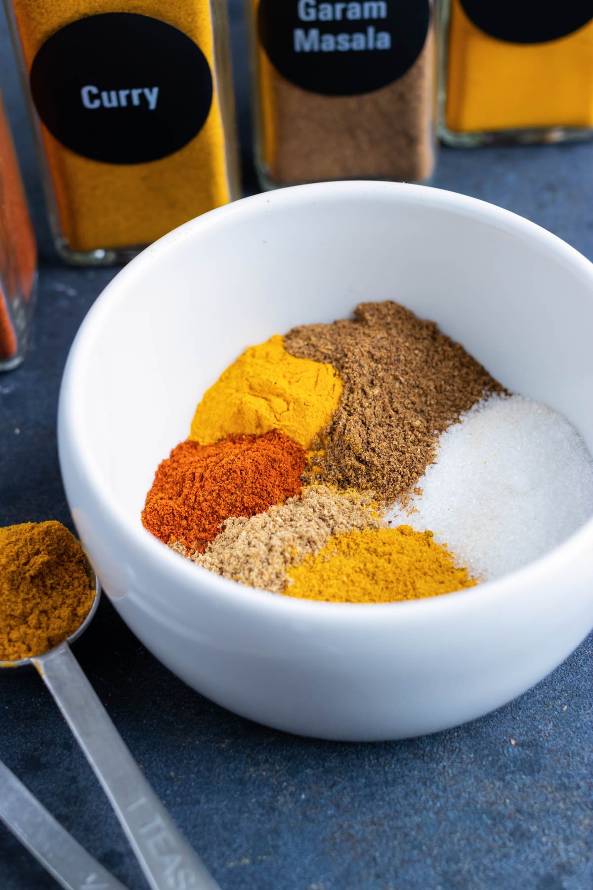 Curry seasoning mix in a white bowl to be used in an Instant Pot Yellow Chicken Curry recipe.