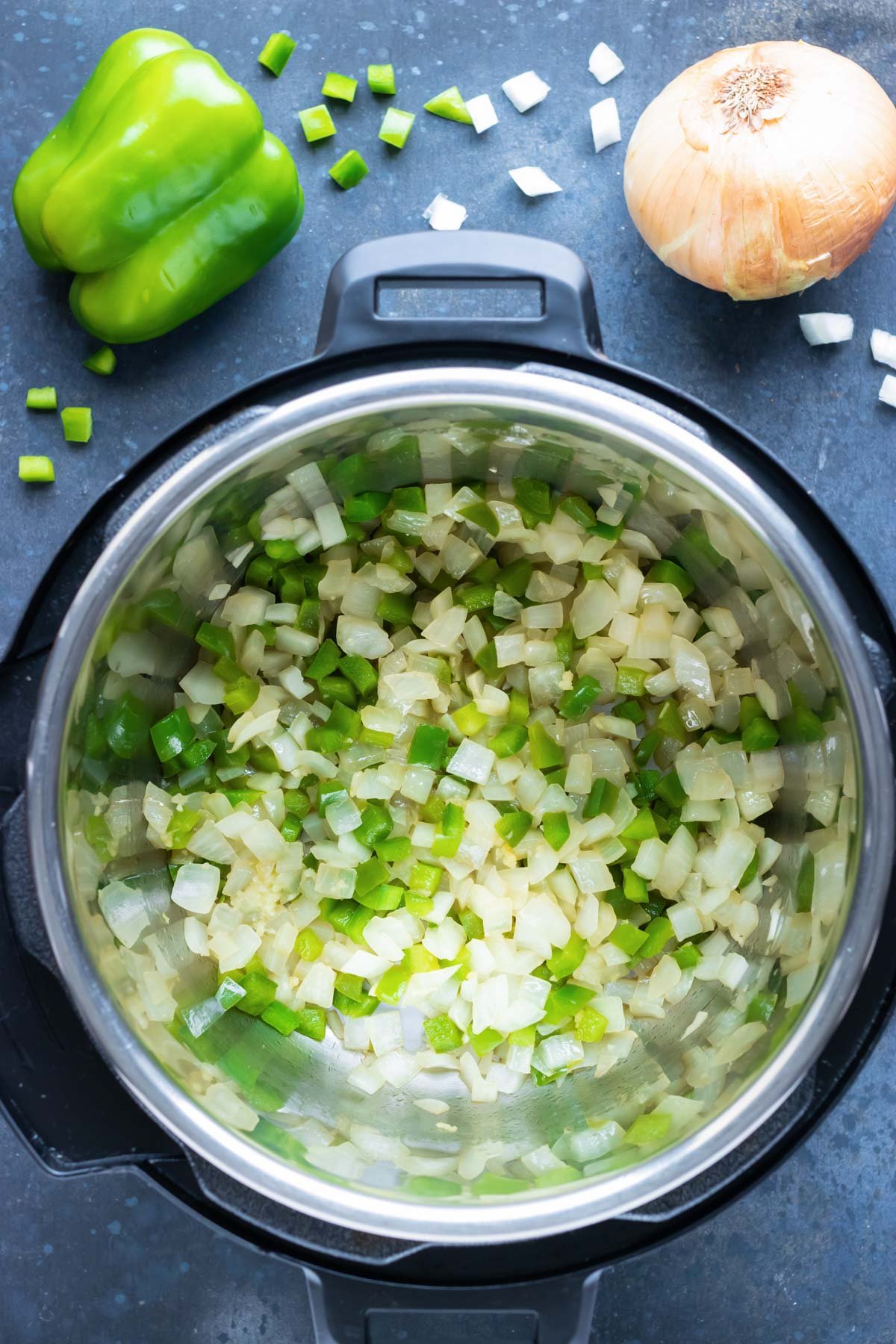 Bell pepper and onions are sauteed in the Instant Pot.