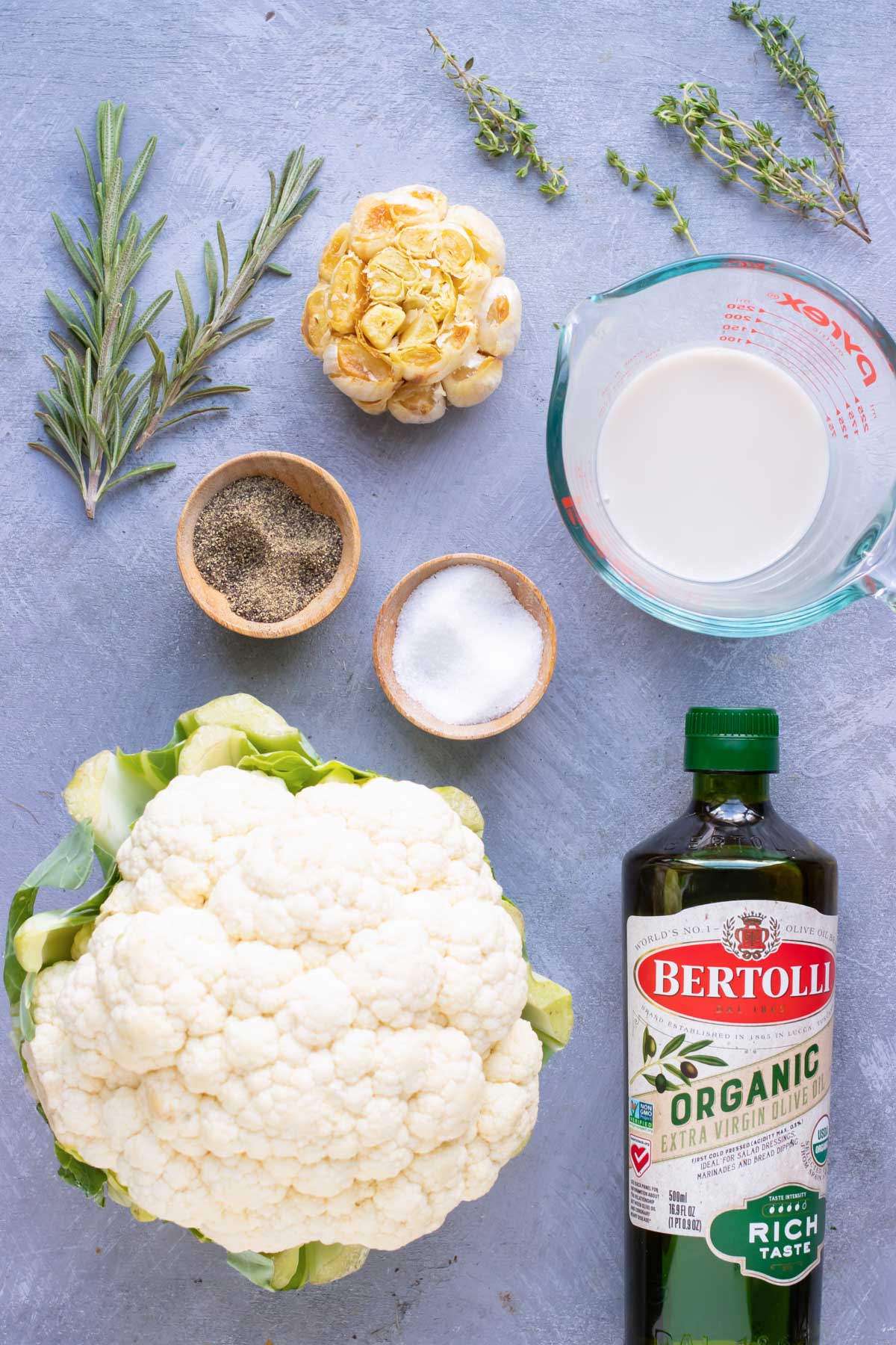 Cauliflower, garlic, oil, milk, and herbs as the ingredients for the best mashed cauliflower potatoes recipe.
