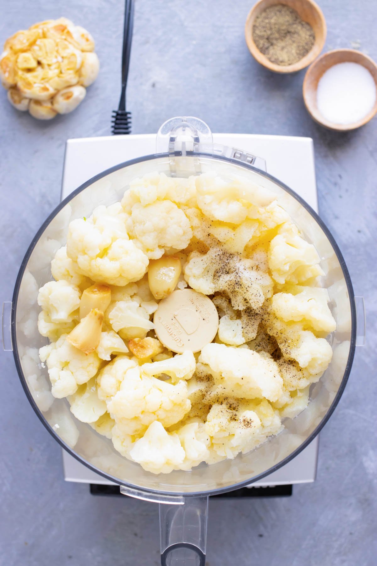 Cauliflower, garlic, and herbs are pureed in a food processor.