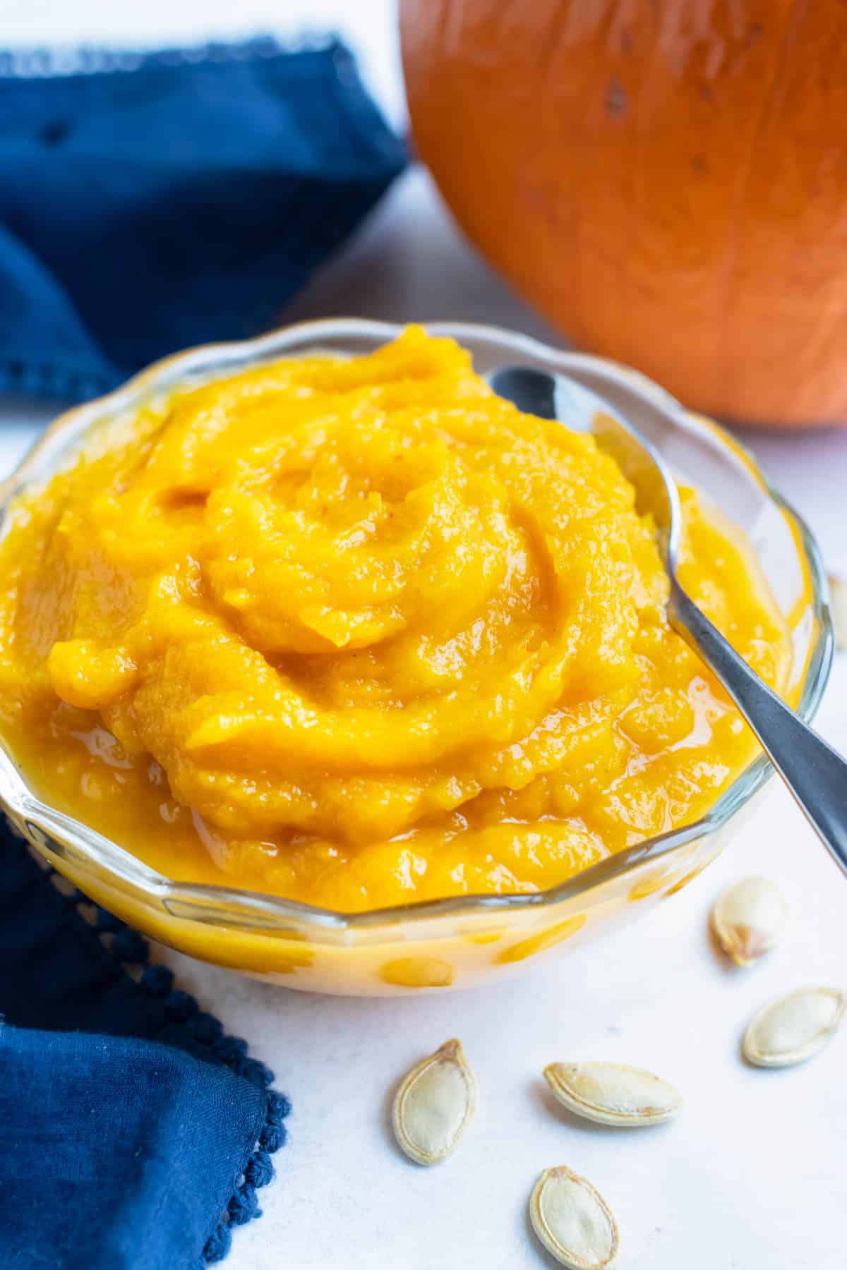 Fresh and creamy pumpkin puree is in a bowl on the counter.