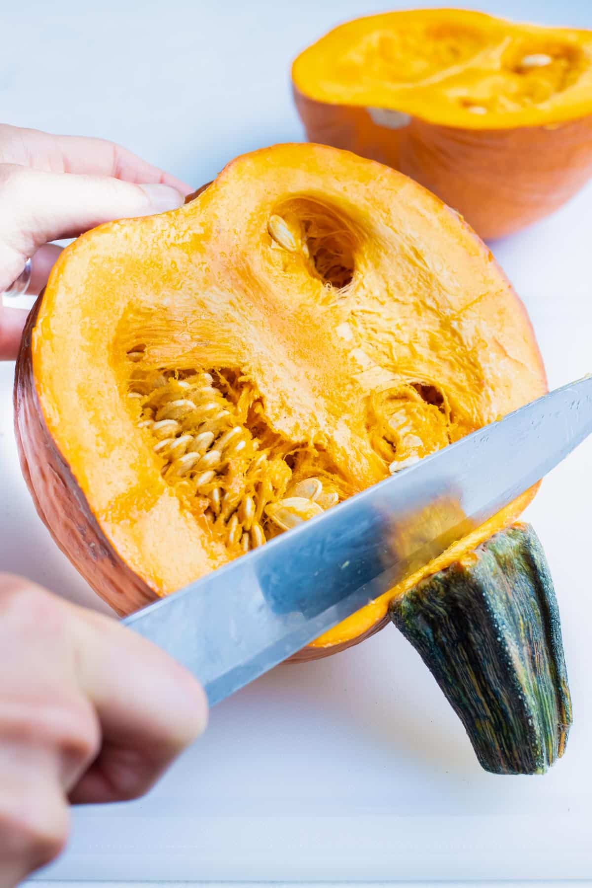 A knife is used to make an incision at the pumpkin stem.