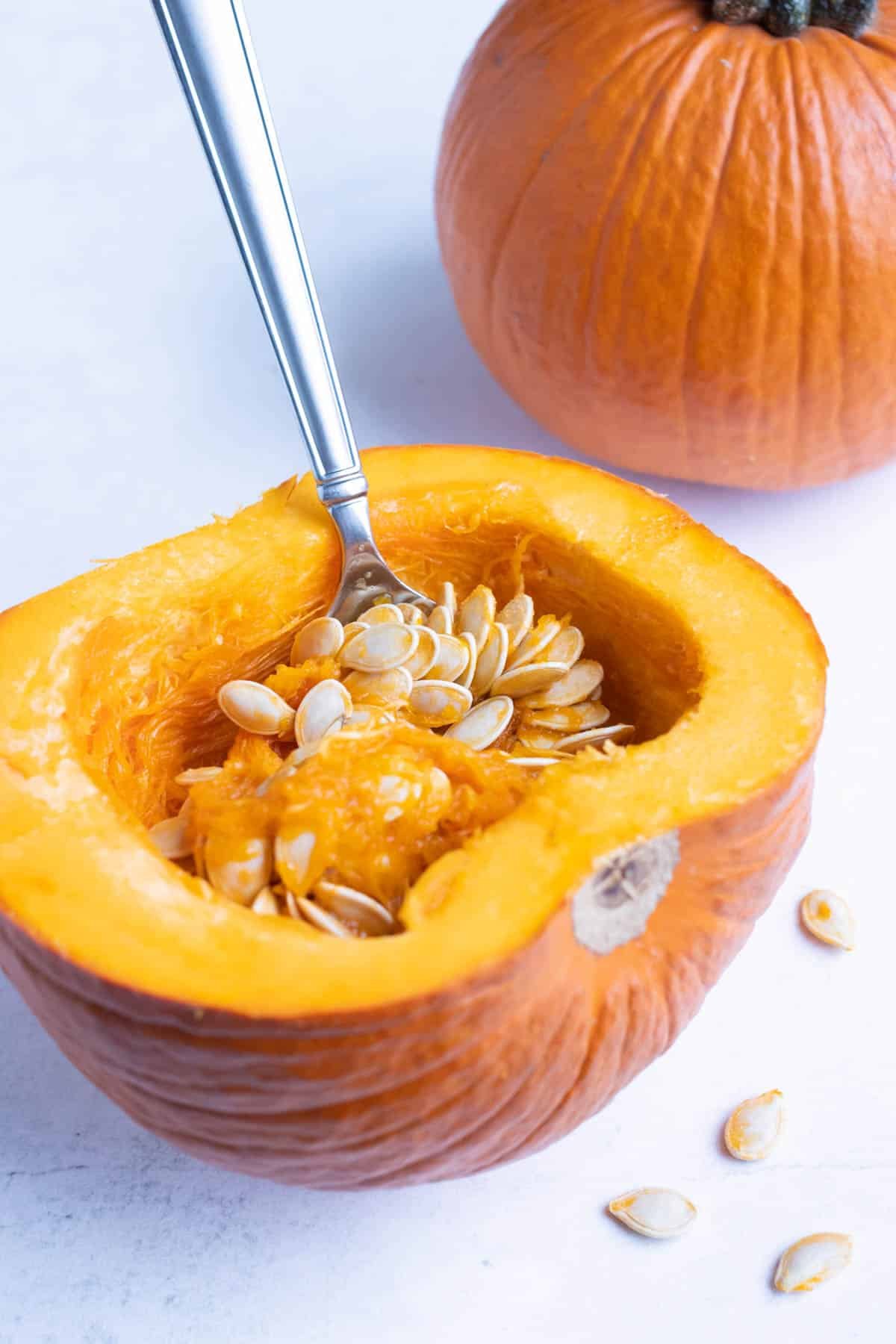 Insides are removed from the pumpkin halves with a spoon.