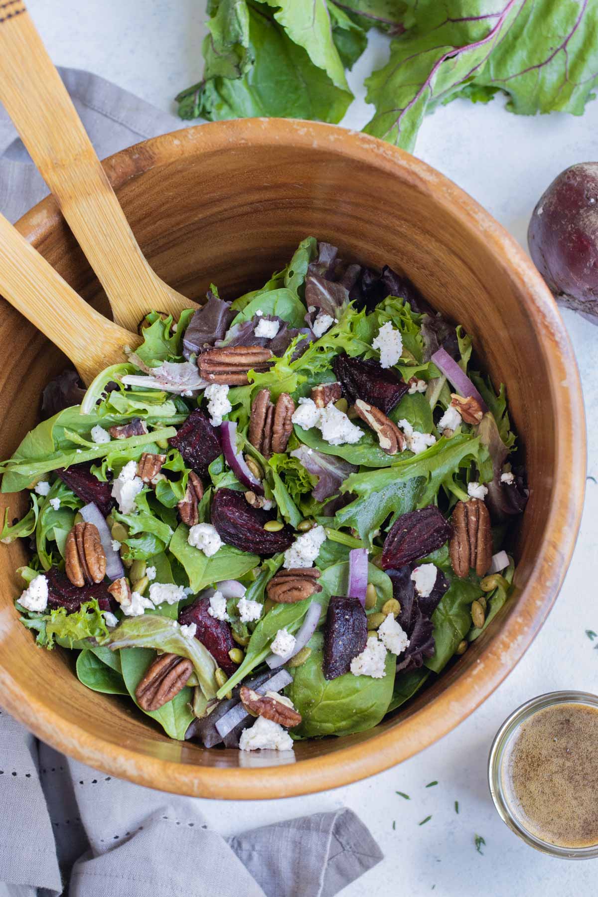 Roasted beet and goat cheese salad is served from a large bowl.