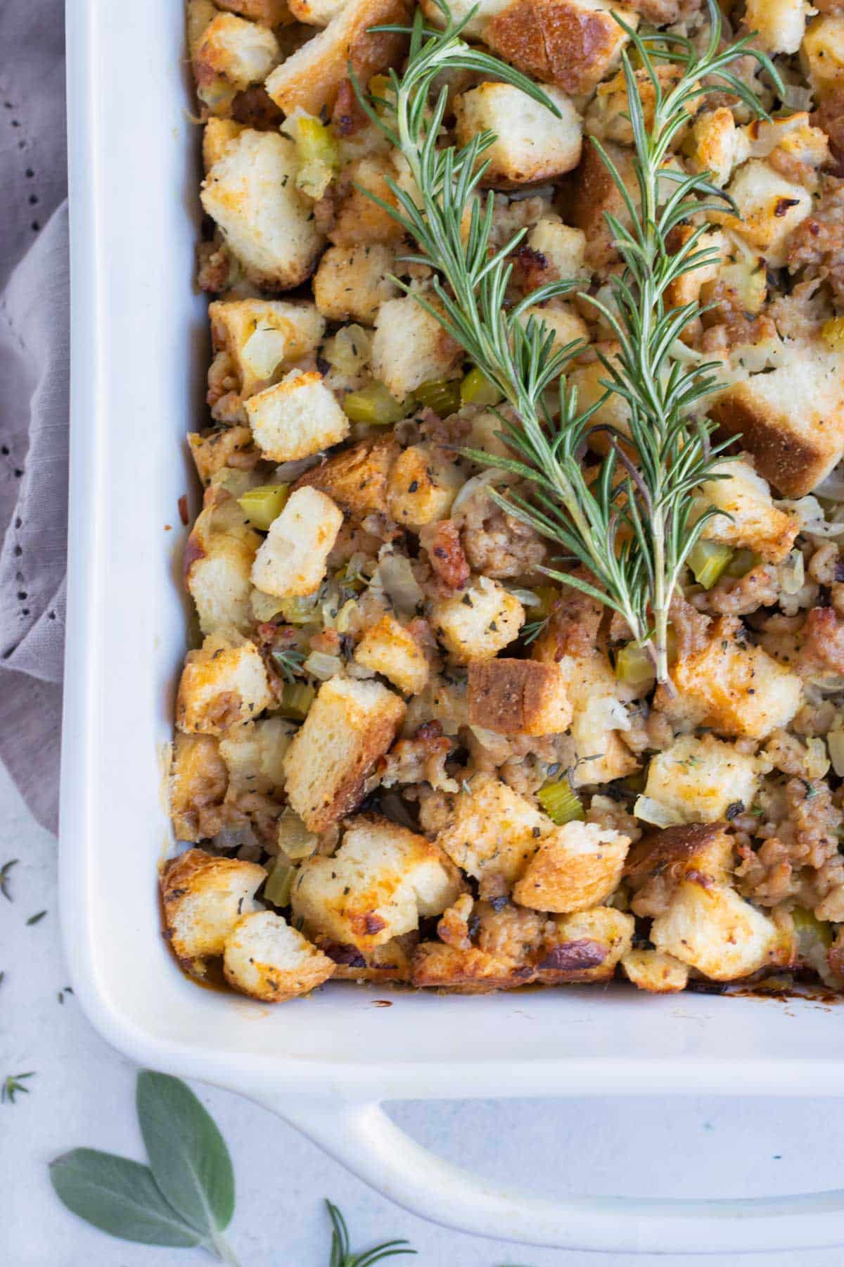 Gluten-free sausage stuffing is topped with fresh herbs before serving.
