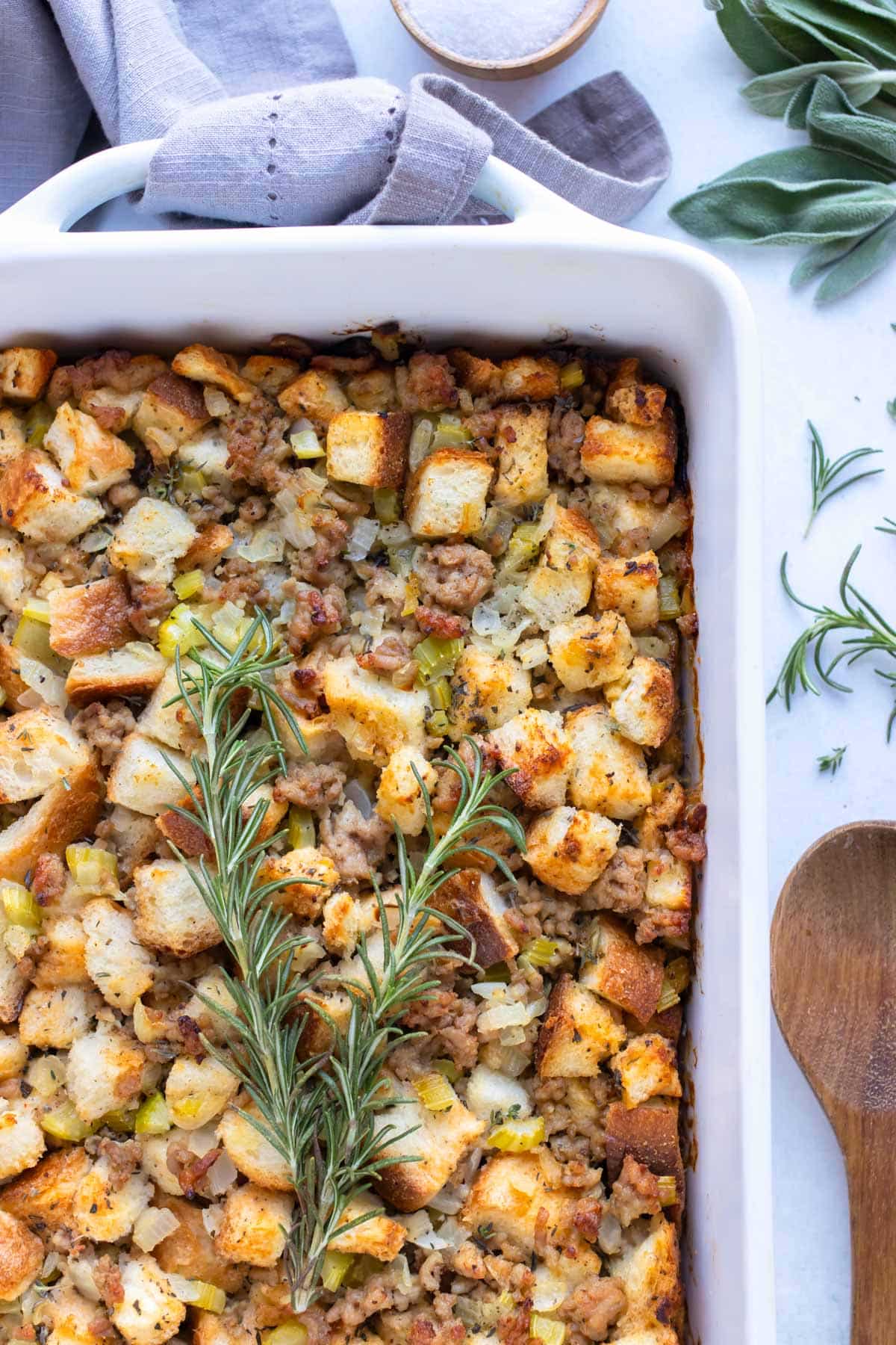 Homemade sausage stuffing is served with fresh herbs for a Fall side dish.