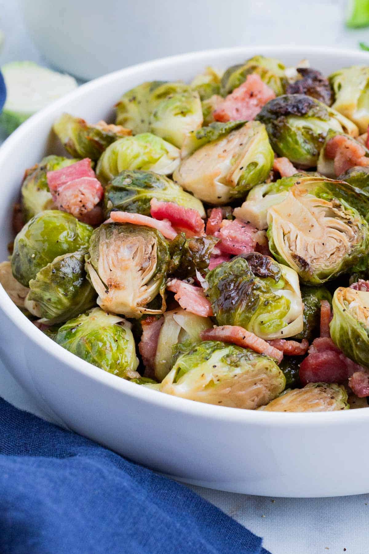 Crispy Brussels sprouts are cooked with bacon in the oven for an easy side.