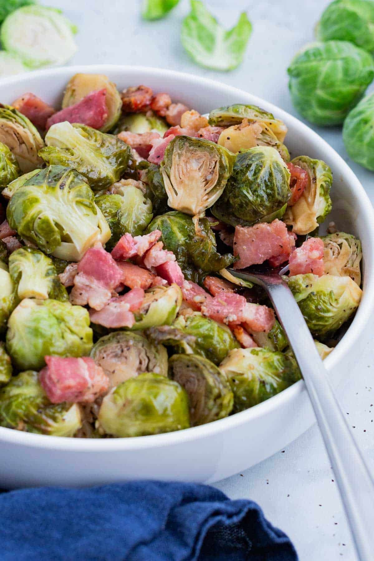 An overhead close-up of maple balsamic Brussels sprouts with crispy bacon and browned, caramelized edges.
