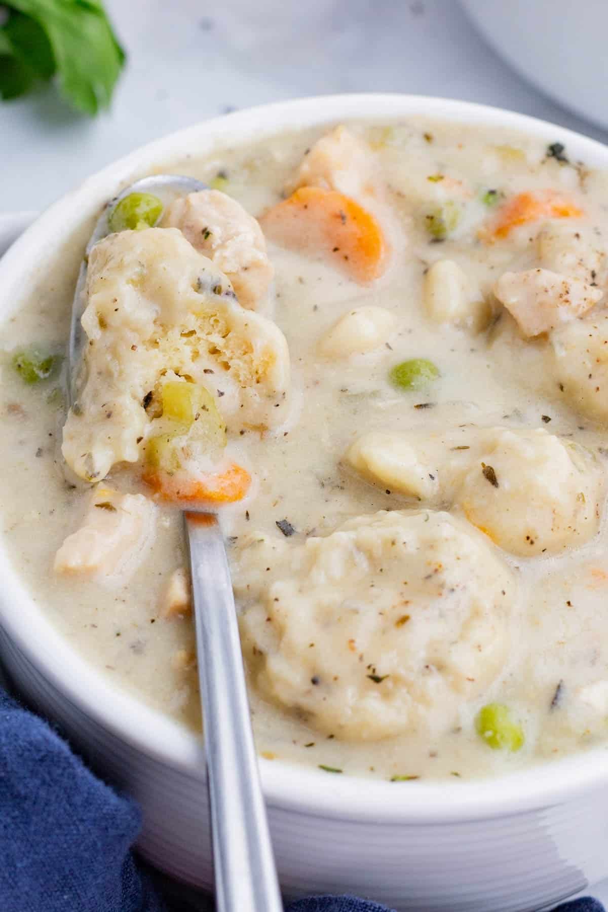 An overhead shot of creamy Chicken Dumpling soup in a bowl.