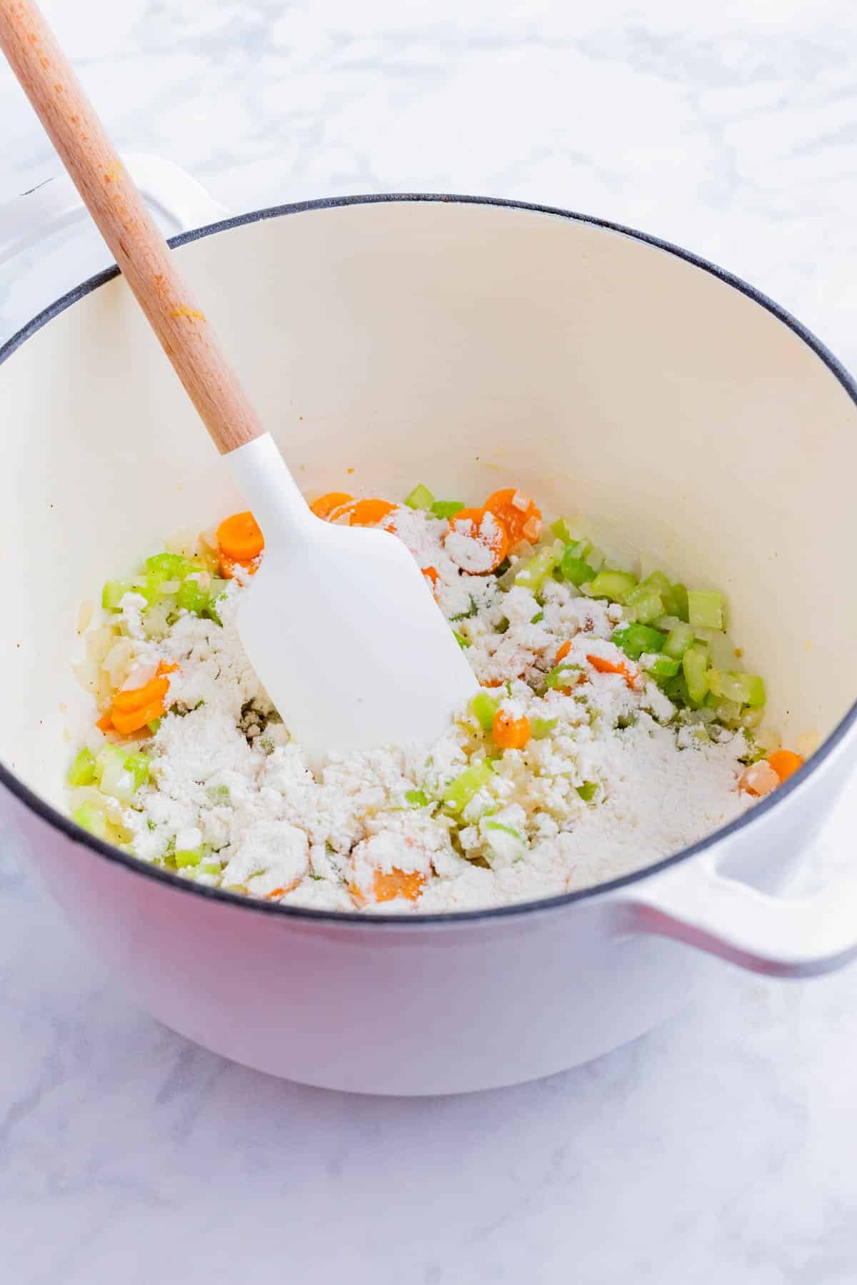 Flour is sprinkled over the cooked veggies.