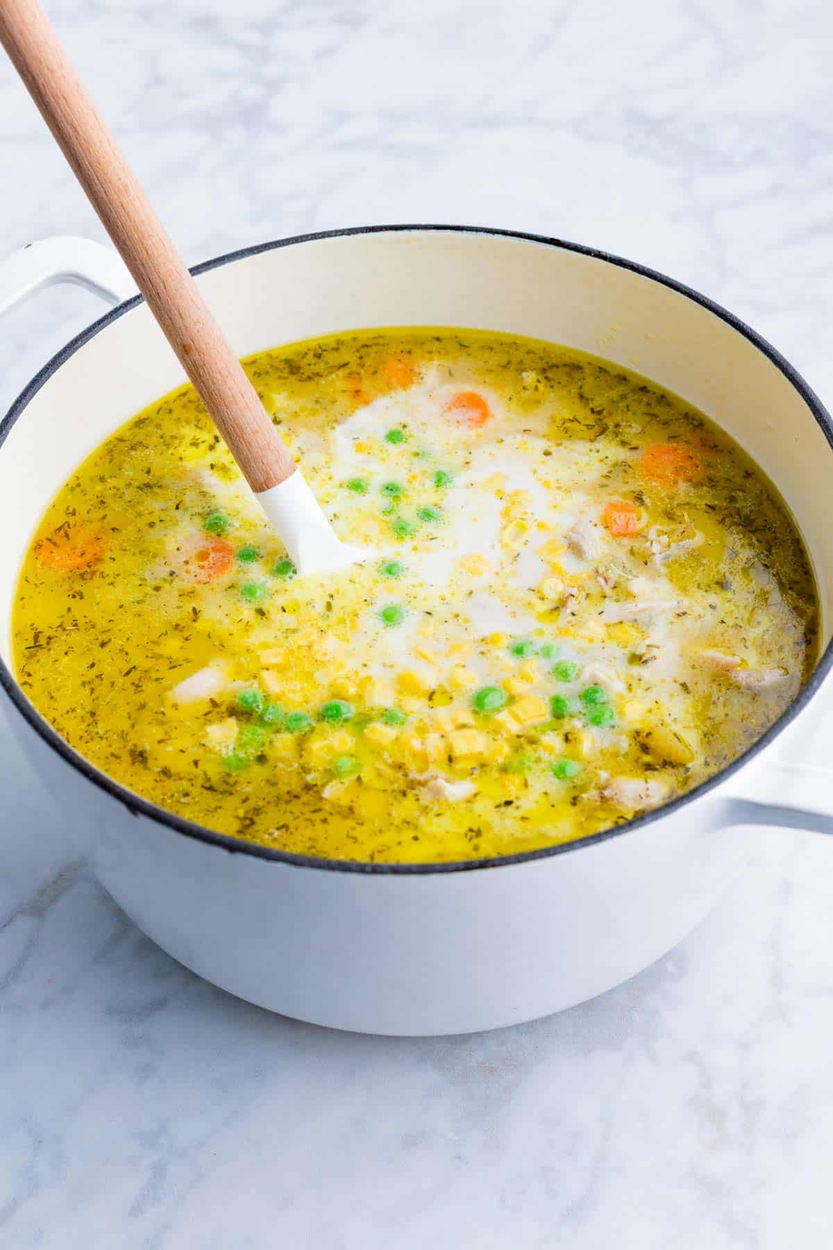 Frozen peas and corn along with milk are added to the soup.