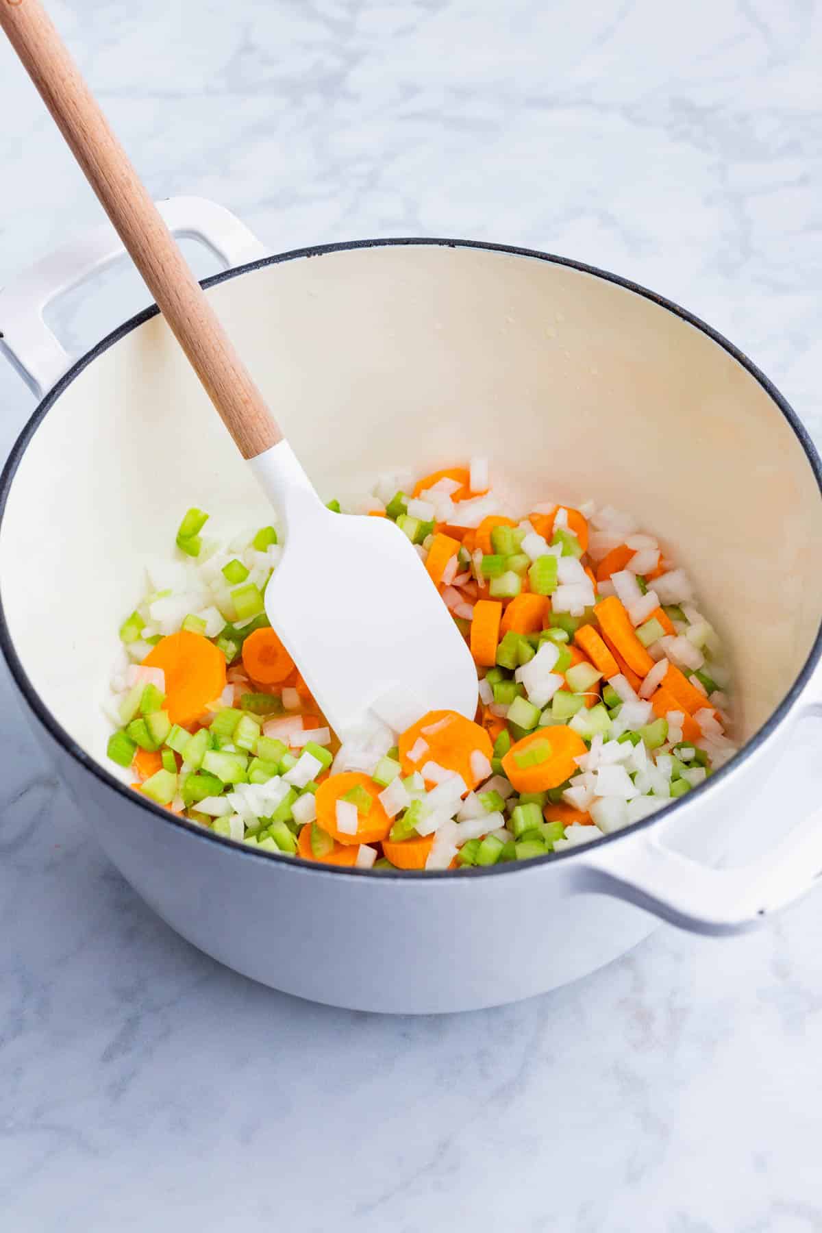 Onion, carrots, and celery are cooked in butter in the Dutch oven.