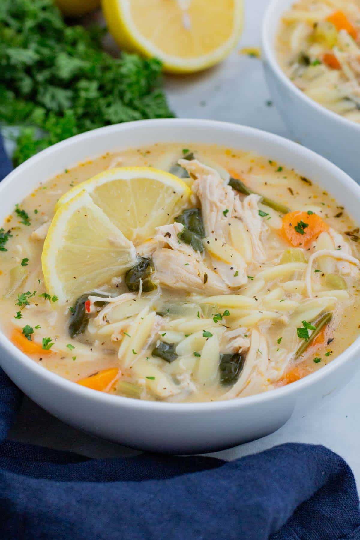 Lemon chicken orzo soup is full of healthy veggies, chicken, and orzo pasta and cooked on the stove.