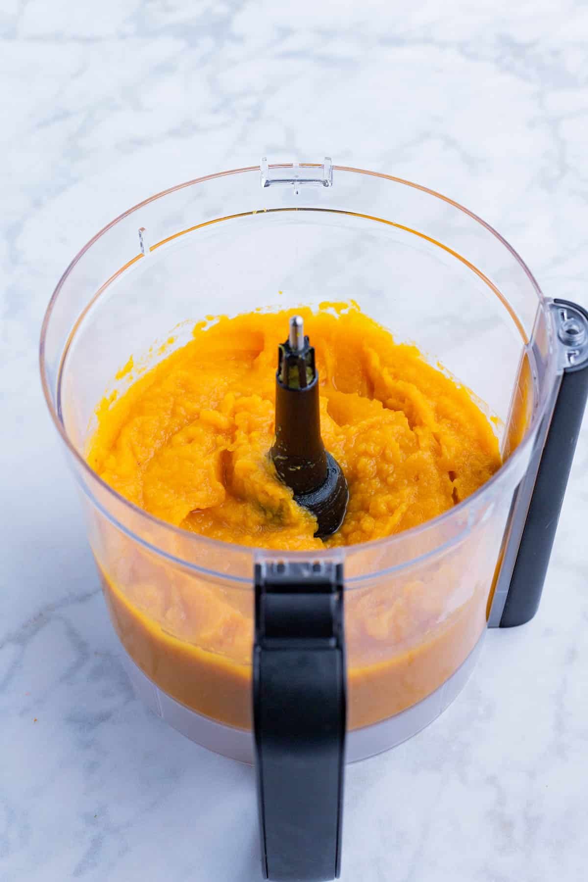 The roasted squash is pureed in a food processor.