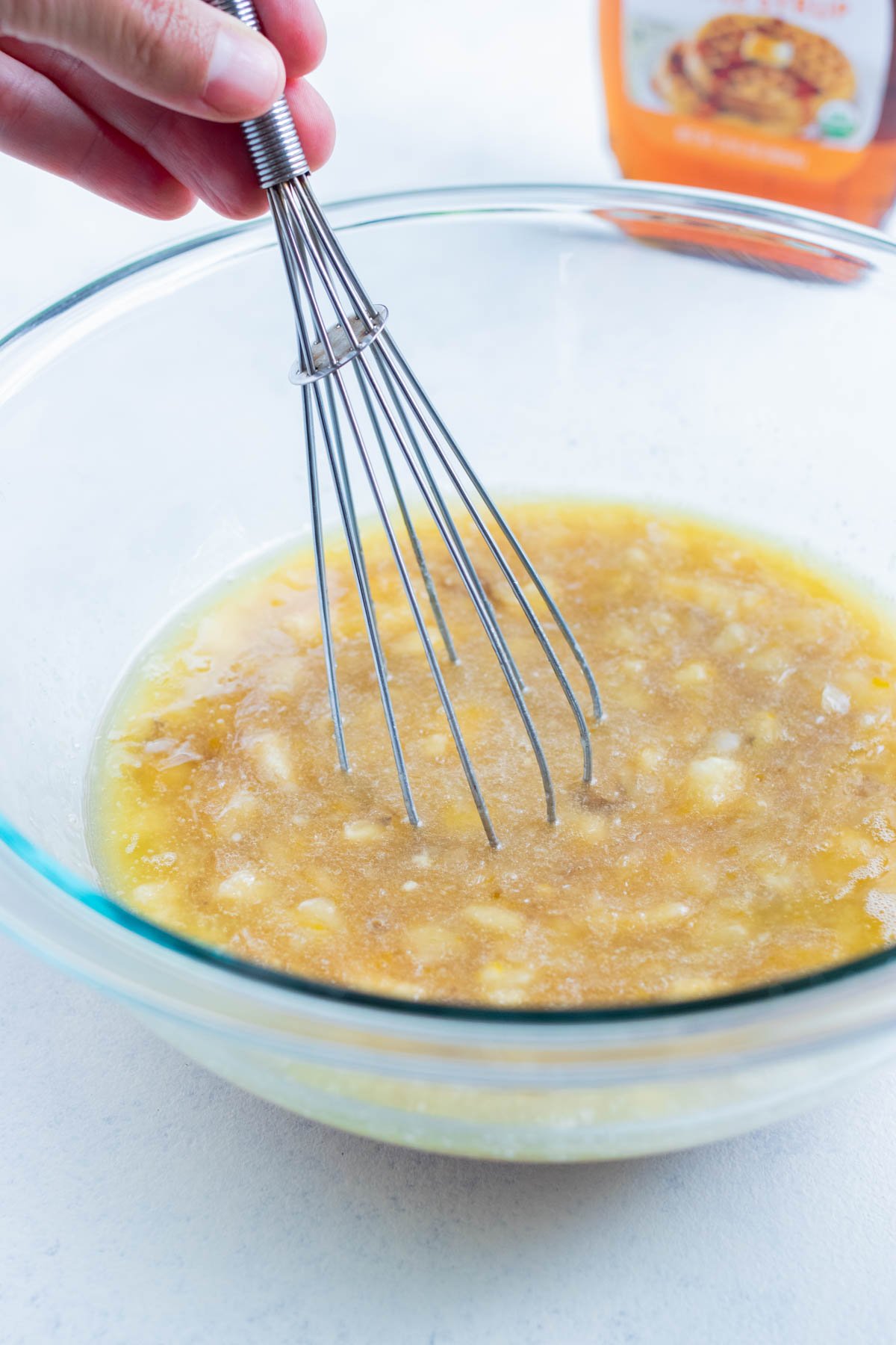 The mashed bananas are mixed together with the eggs in a bowl.